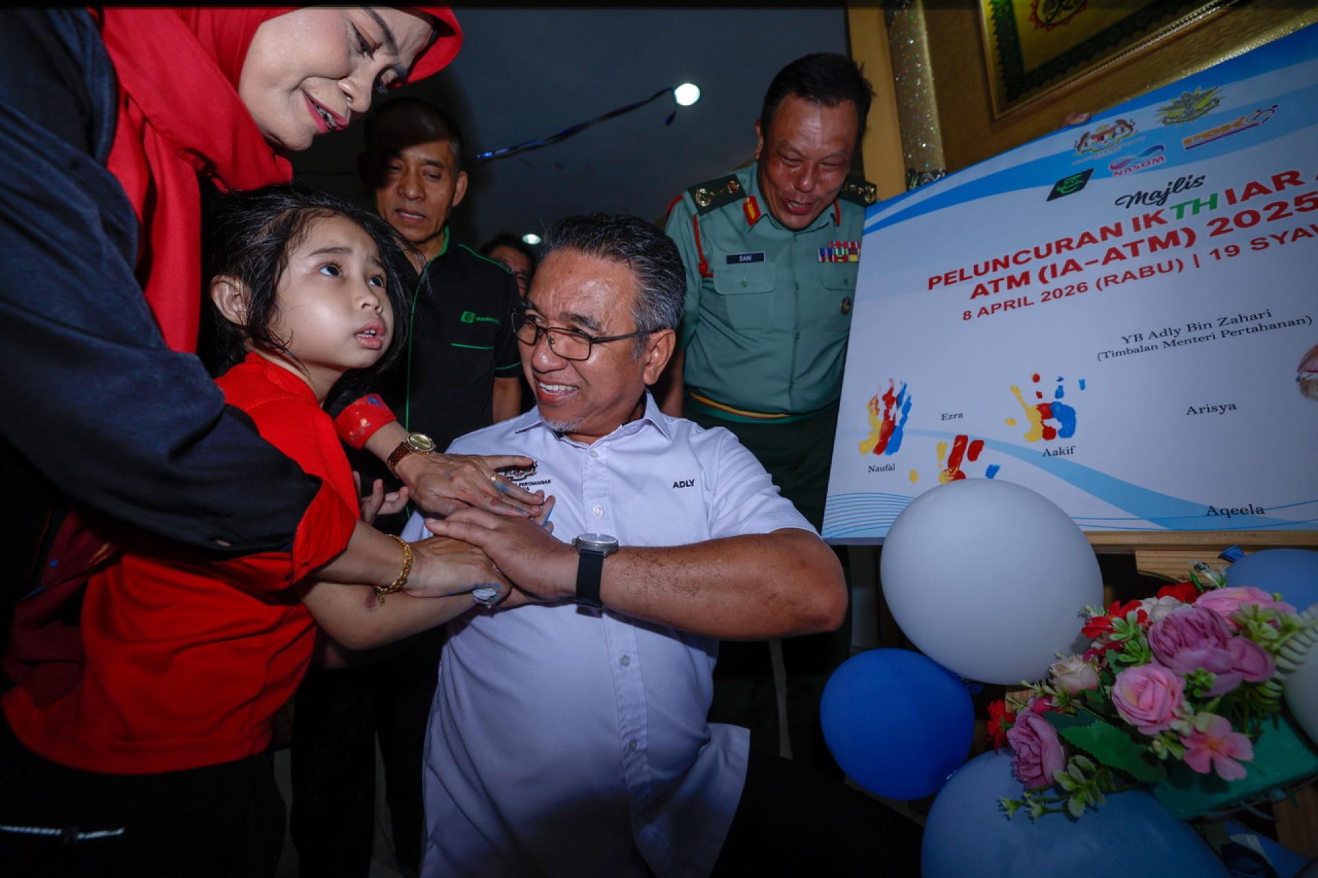 阿德里（前右）为大马武装部队自闭症关怀计划主持推介礼后，与小孩们互动。
