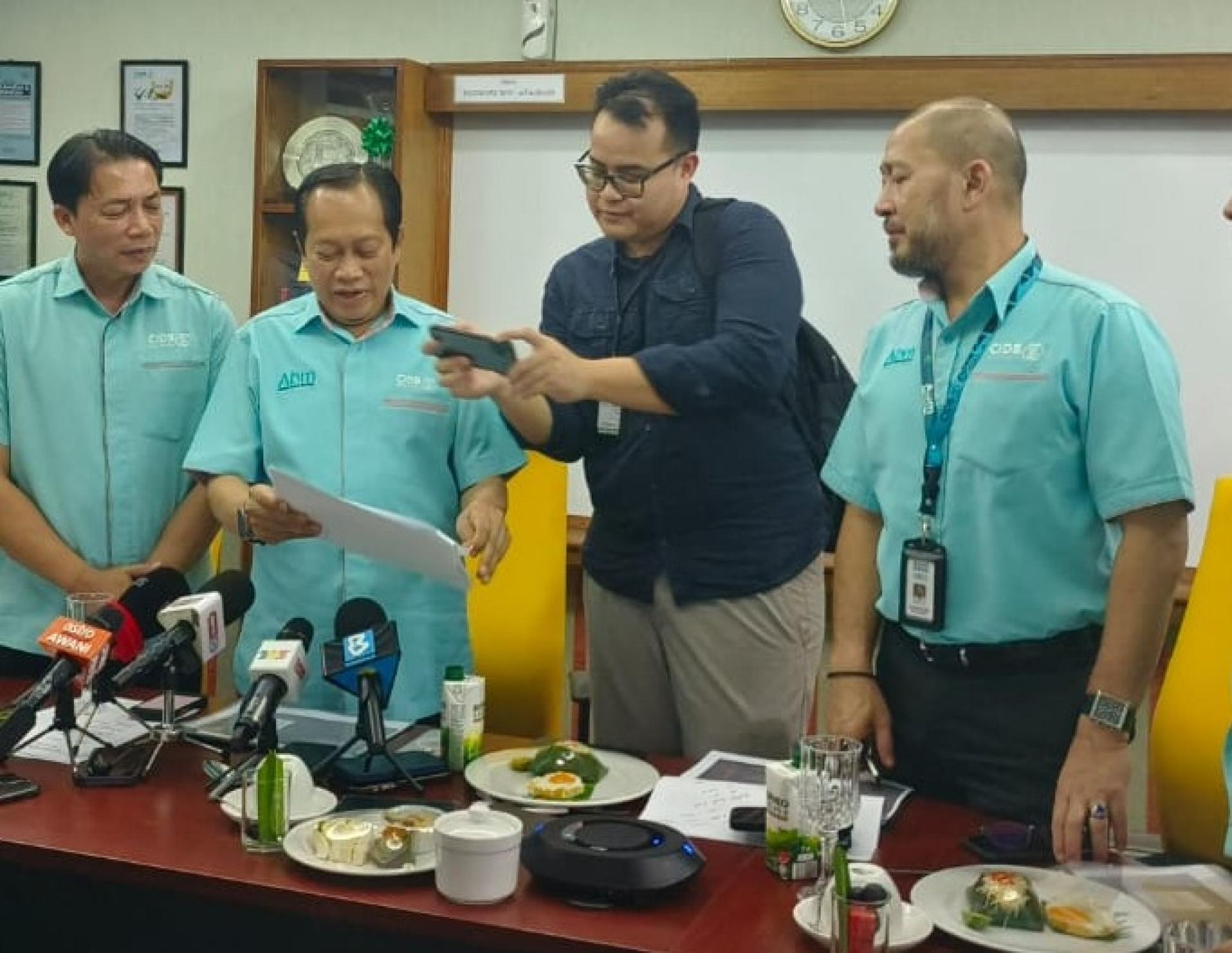 工程部副部长拿督斯里马斯兰（左2）将资料让给在场媒体拍摄。