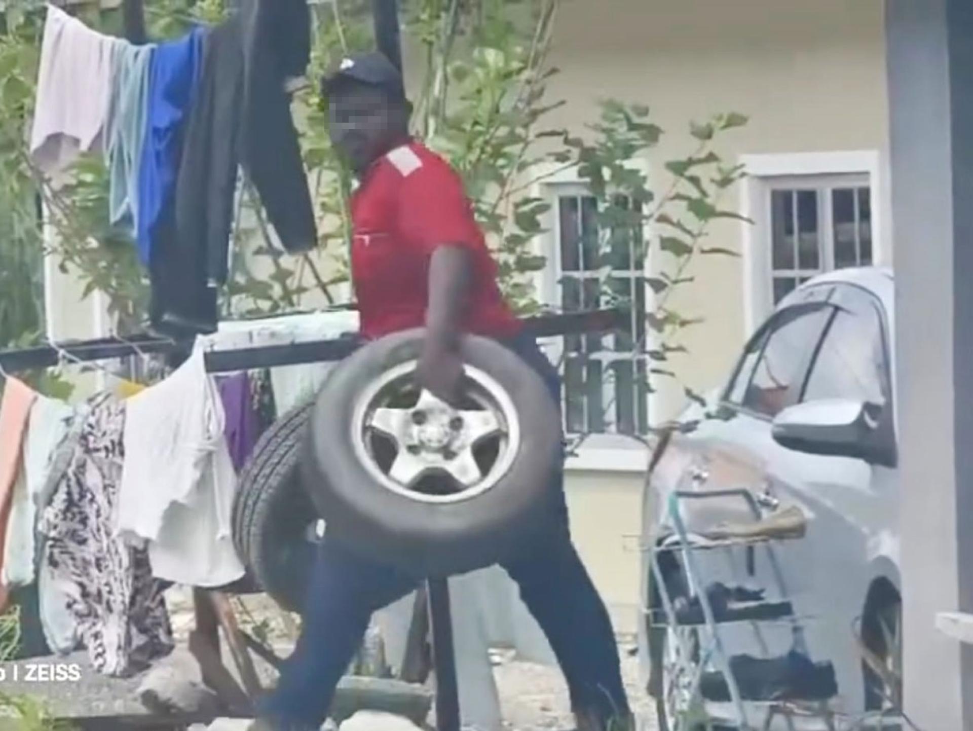 男子取走两个轮胎和轮辋。