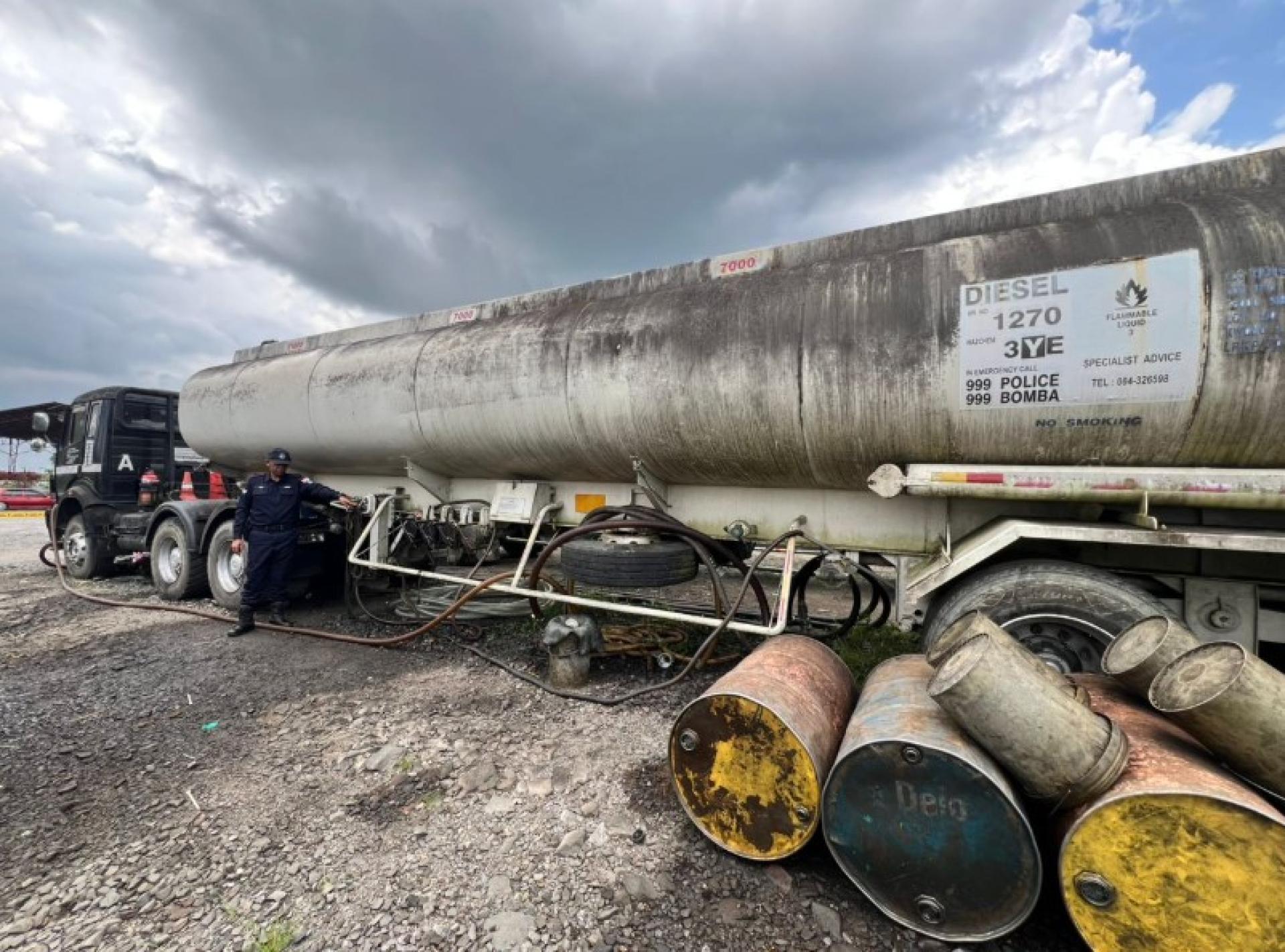 海事警察在诗巫行动中检查油罐车及查获的柴油。