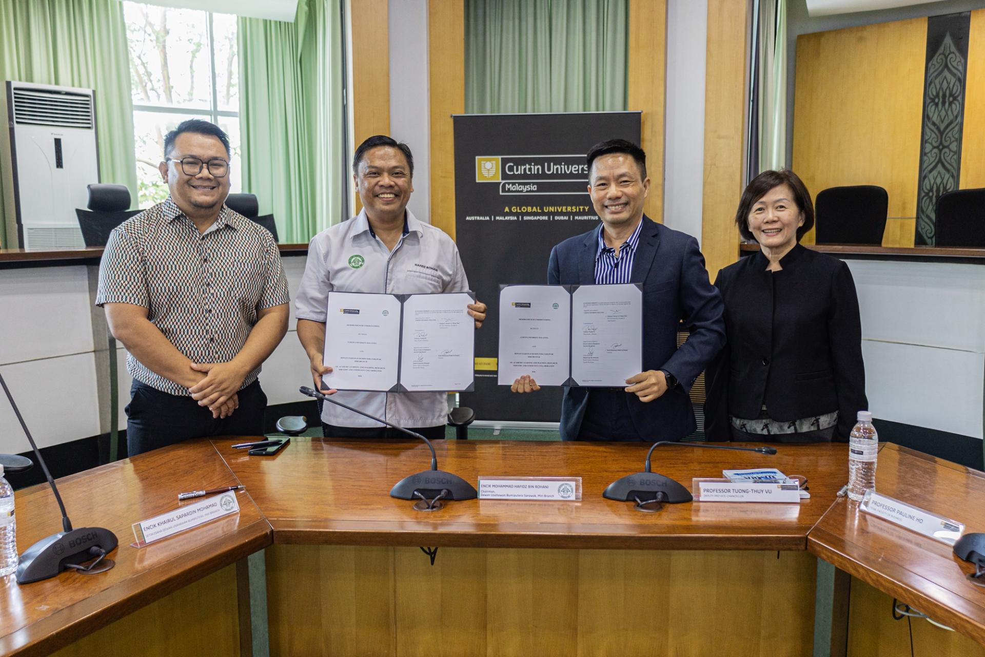 科廷大学与砂拉越土著企业家公会美里分会代表展示已签署的备忘录。