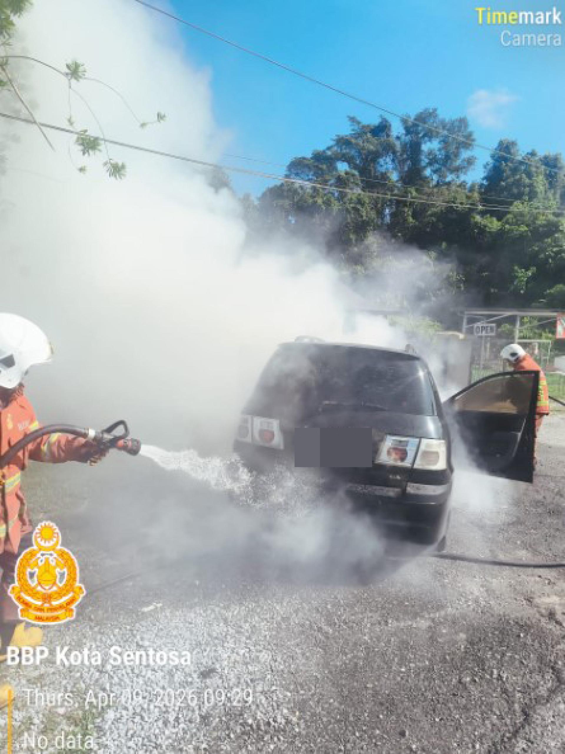 消防员正在扑灭燃烧的汽车。