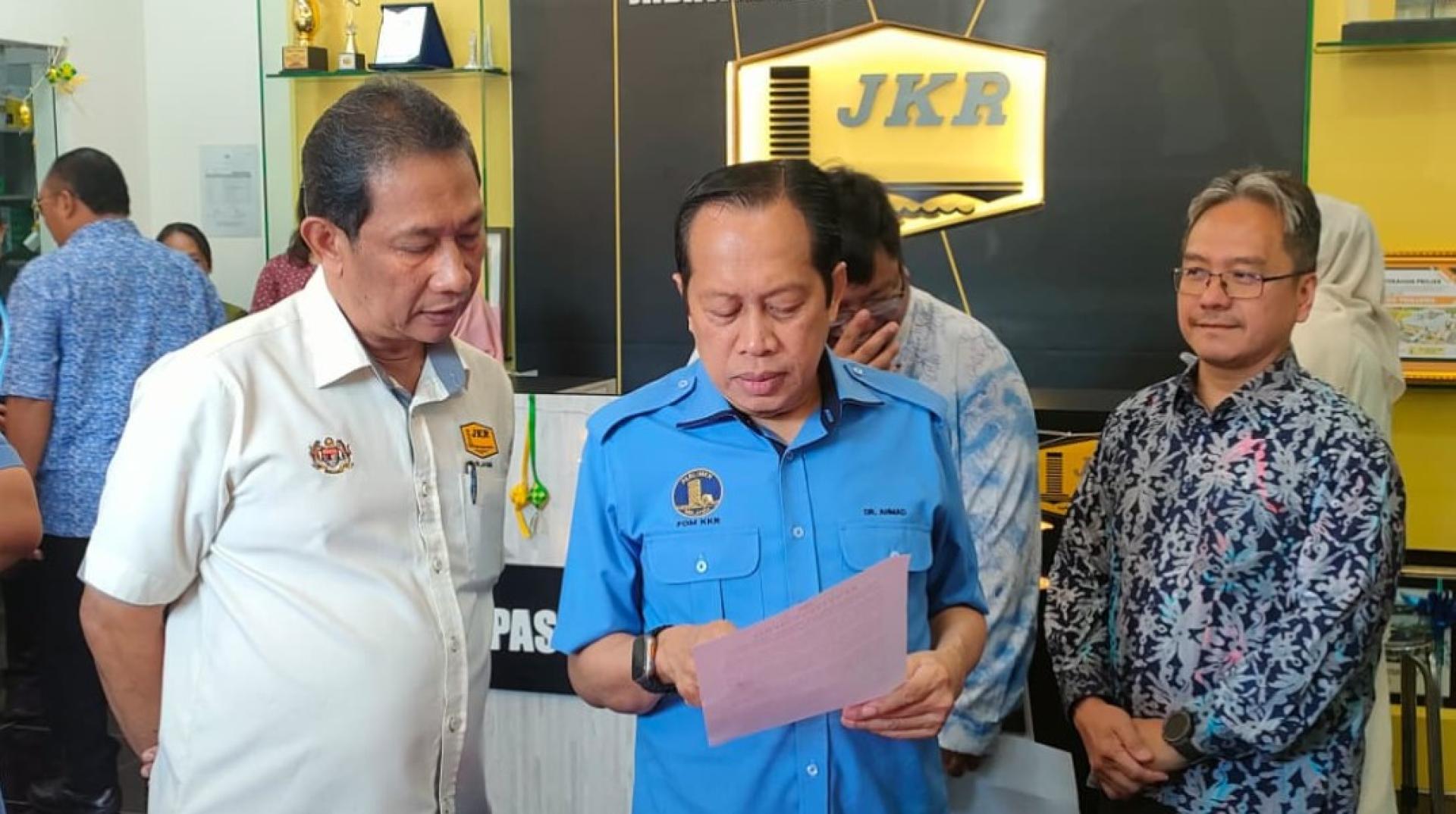 阿末马斯兰（右）聆听总监拿督贾斯米瓦哈的汇报。