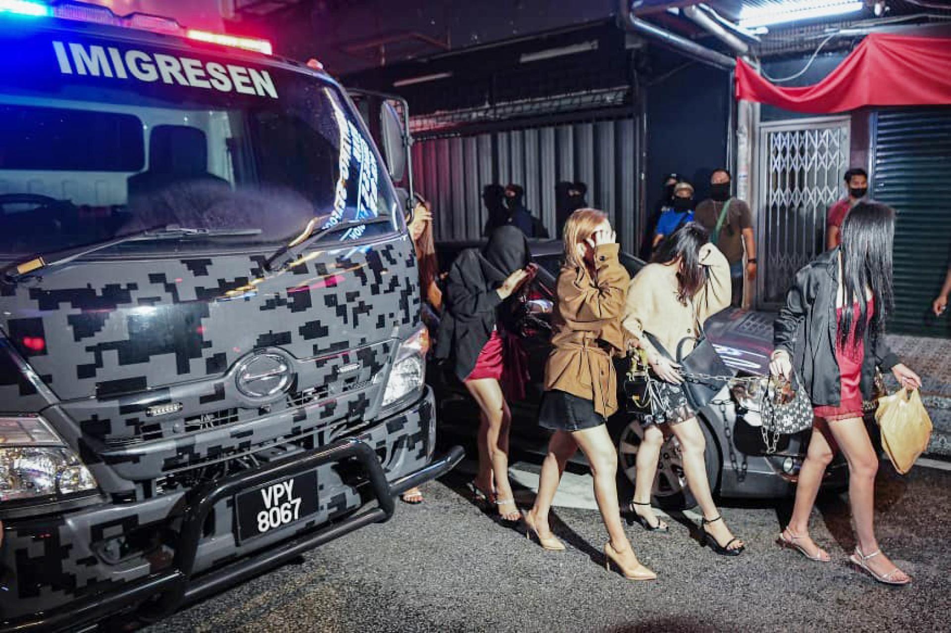 女郎被扣留后带走接受调查。