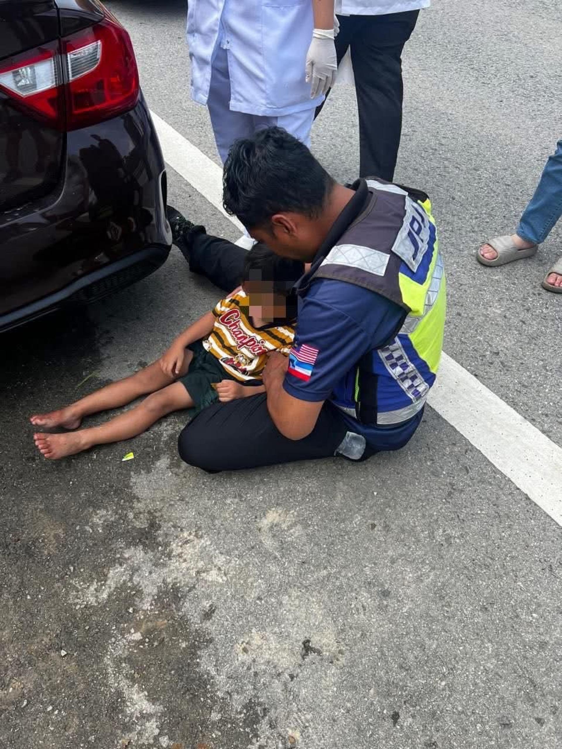 执勤中的陆路交通局执法人员伸出援手，协助涉及事故的一名男童及一名成年男子。