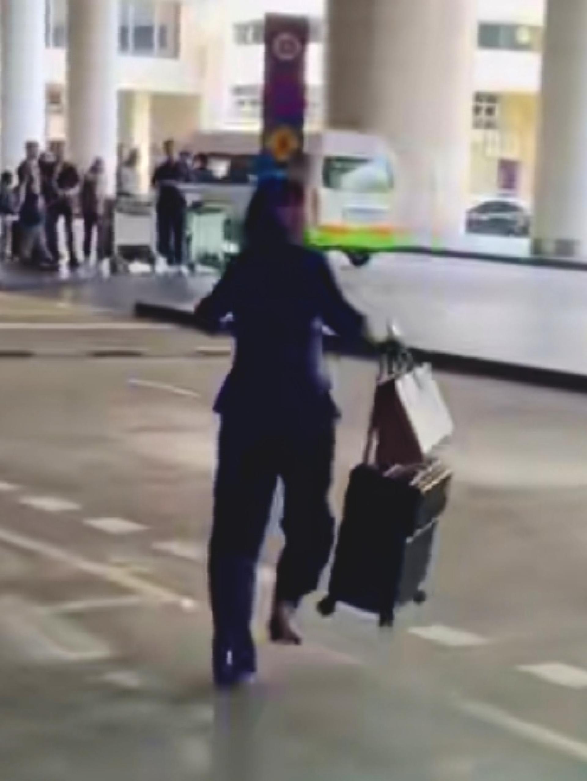 女子被追问是否向他人借钱时没有回应，反而匆匆离开。（网络视频截图）