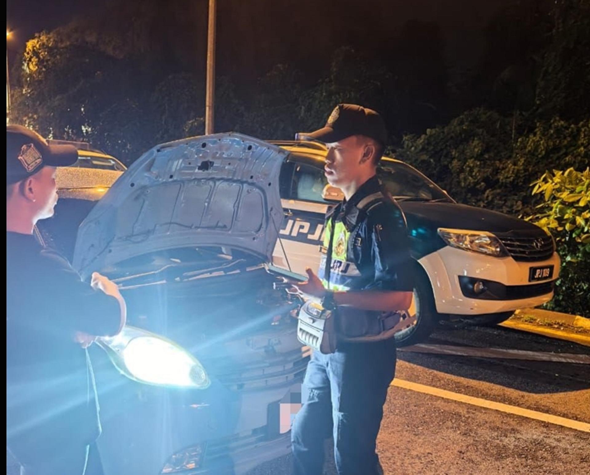 陆交局执法人员对违规车辆展开检查。