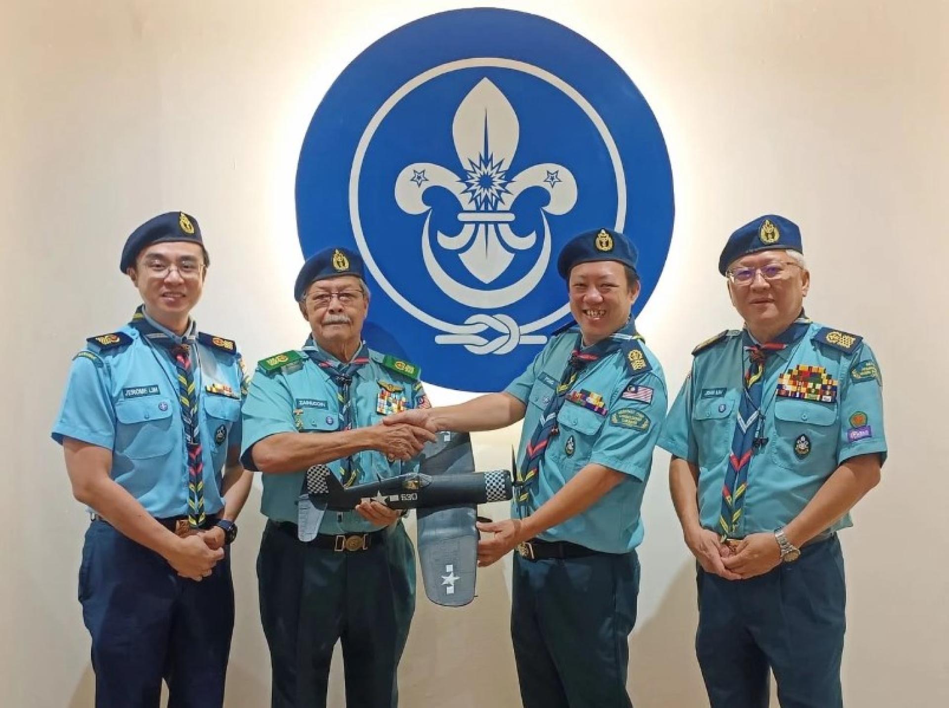 再努丁（左2）将战机模型移交Fong Voon Chon，由John Lim Boon Beng（右）及Jerome Lim（左）见证。