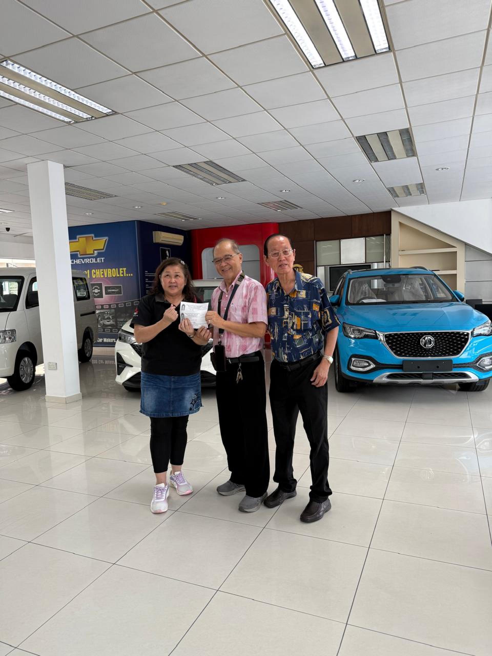 詹道丁（中）移交其姐姐张爱英及姐夫谢仰贤之善款，由该会理事代表接收。