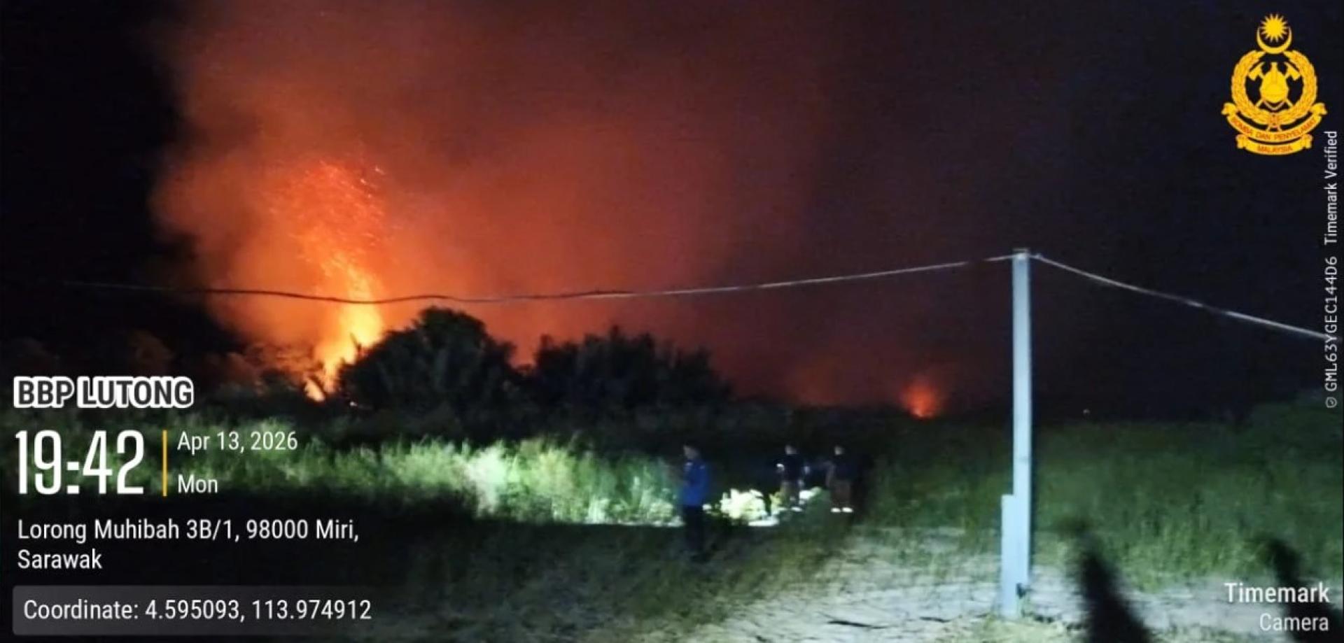 火焰吞噬丹绒巴南沿海灌木林，因地形受限，消防员只能在远距离控制火势蔓延。