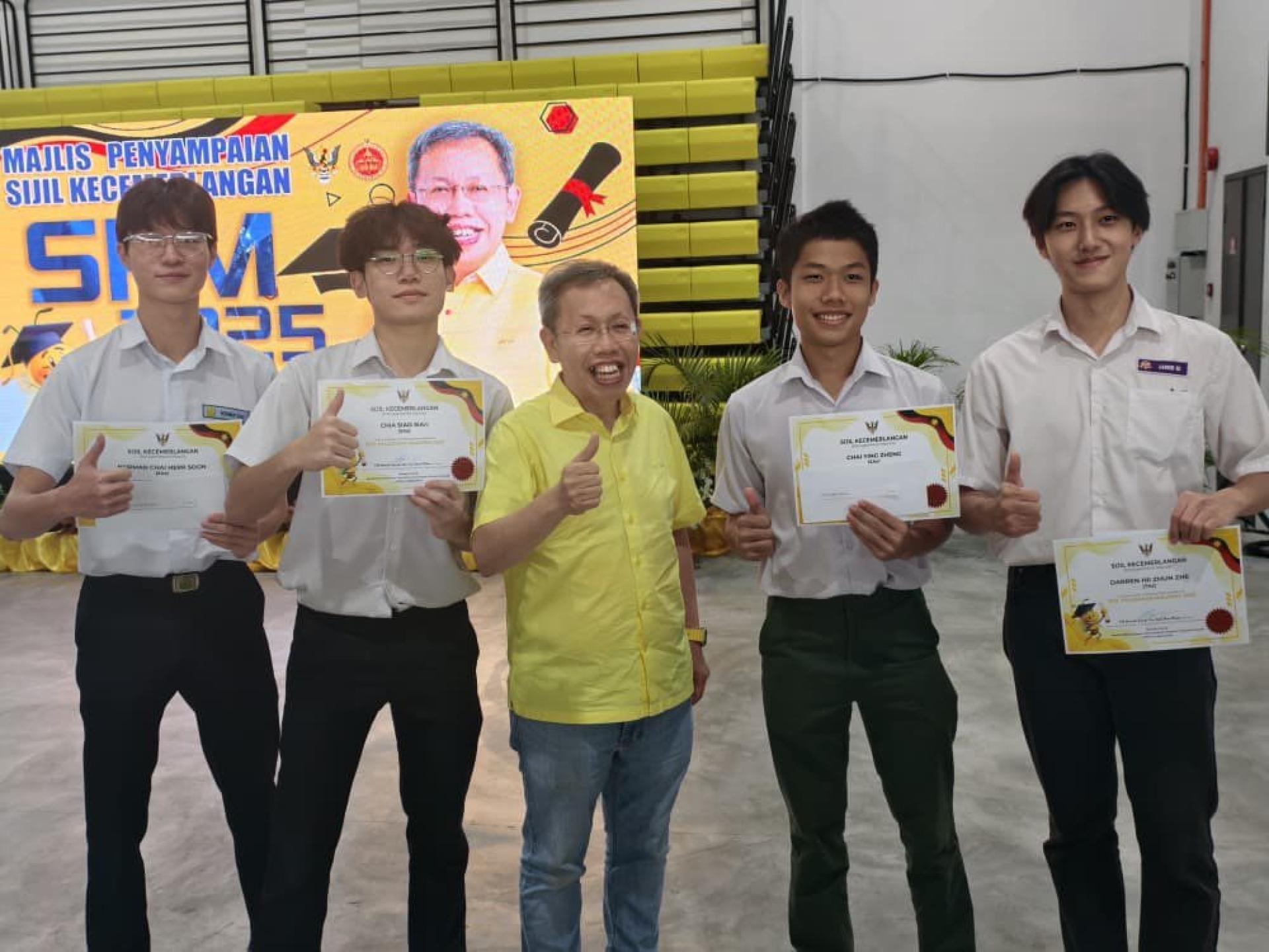 获得奖励金的优异生高兴的和拿督阿玛沈桂贤合影留念。