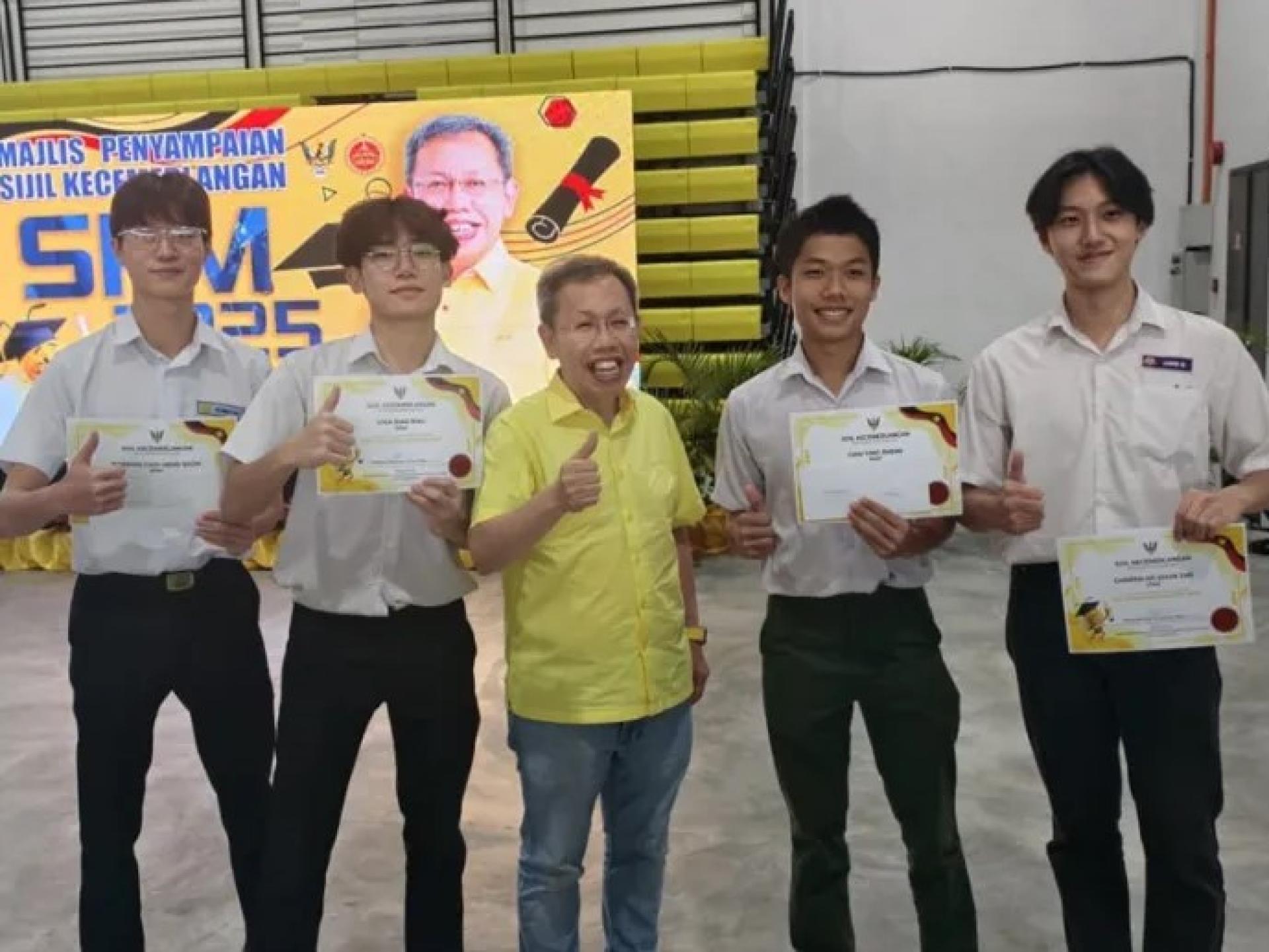 沈桂贤（穿黄色衬衫）与学生在石角洪清河综合礼堂颁奖仪式后合影。