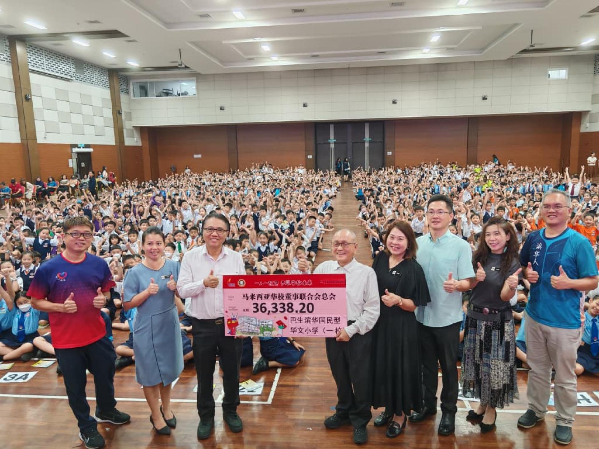 巴生滨华一校师生踊跃响应“一人一红包”募捐计划，由颜金松（右5）移交3万6338令吉20仙予董总，由陈云枫（左3）代表接领模拟支票。