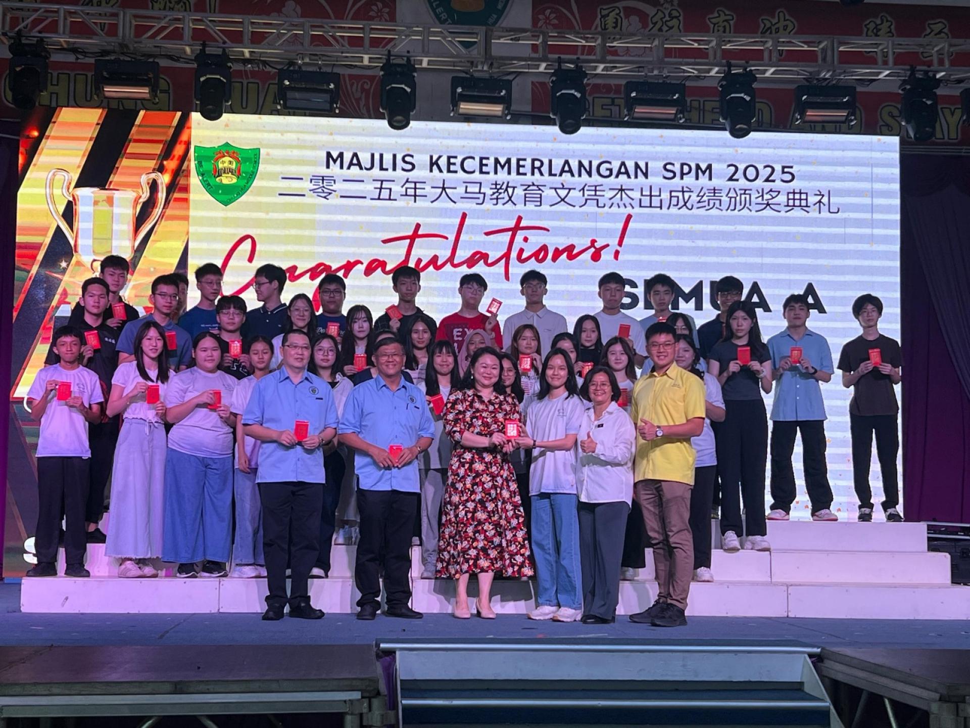 陈丽黛（前排左三）颁发奖金予在大马教育文凭考试中考获11科A（全科）的郭靖詷（前排右三）。