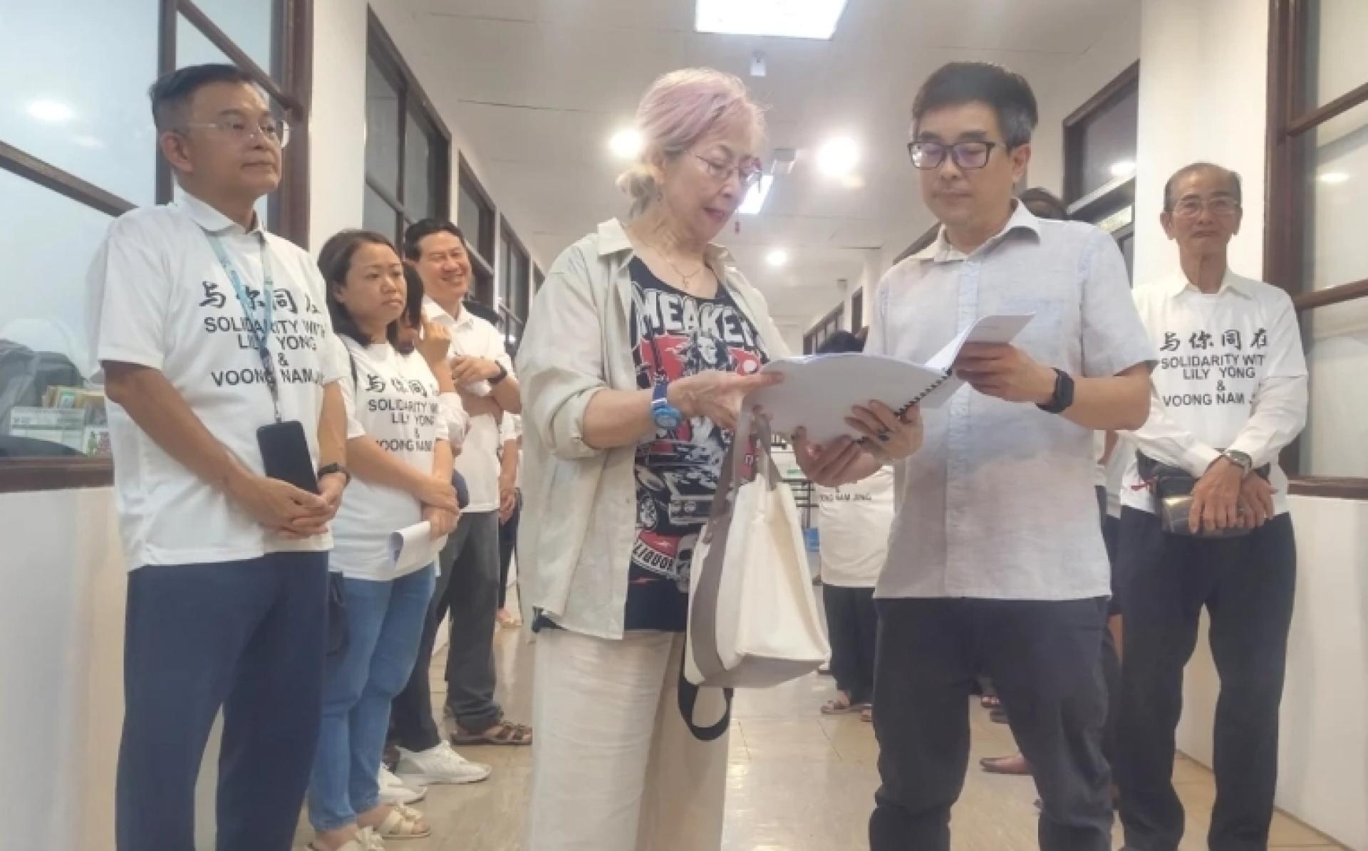 拿督杨莉（左）将上诉信移交到党总部，并由党总部执行秘书罗益忠代为签收。