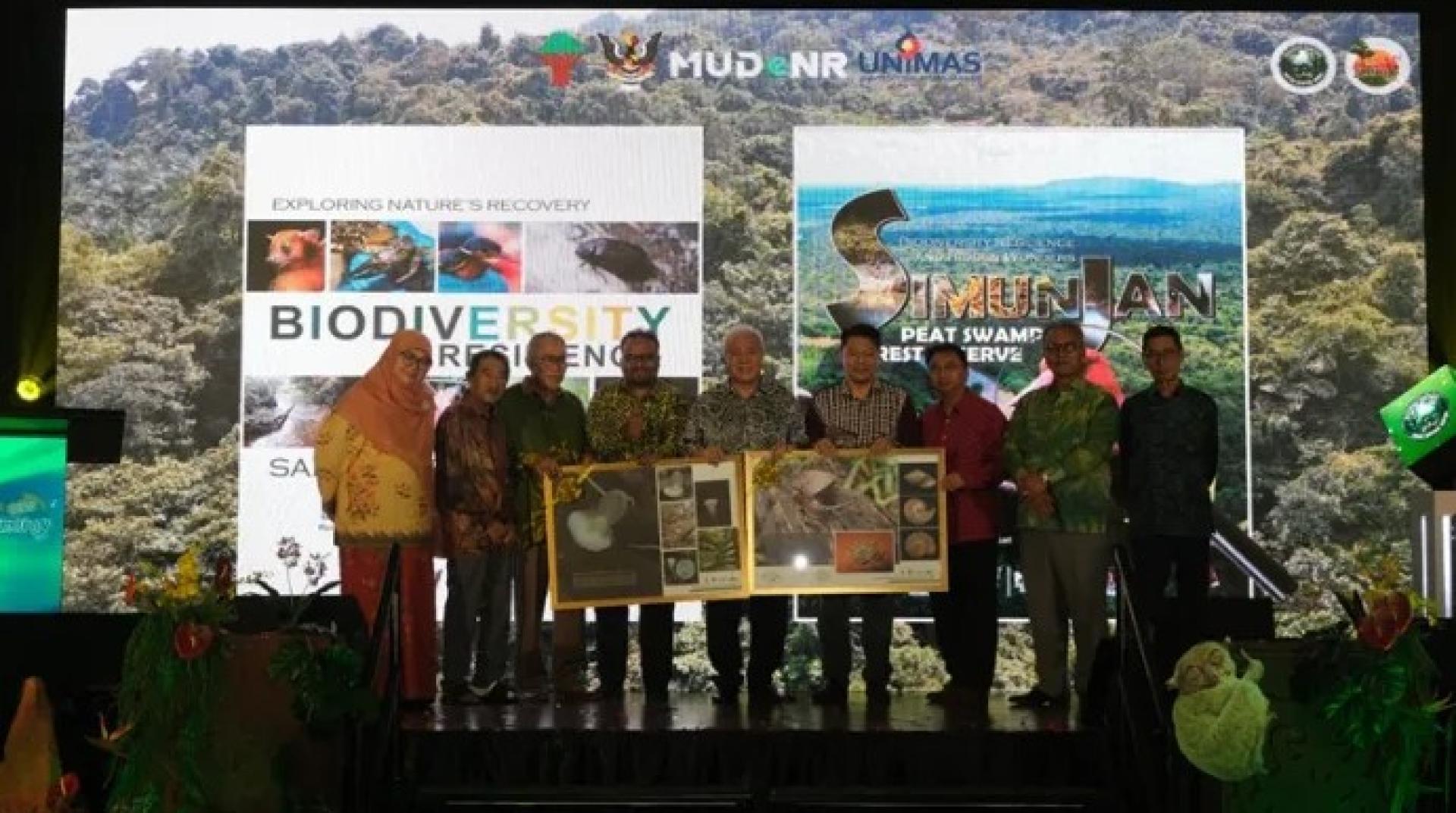 哈姆登（右3）与阿旺登雅（中）及其他嘉宾在古晋一家酒店举行的2026年萨巴与实文然森林保护区科学考察研讨会开幕式上，展示砂拉越森林中新发现物种照片。