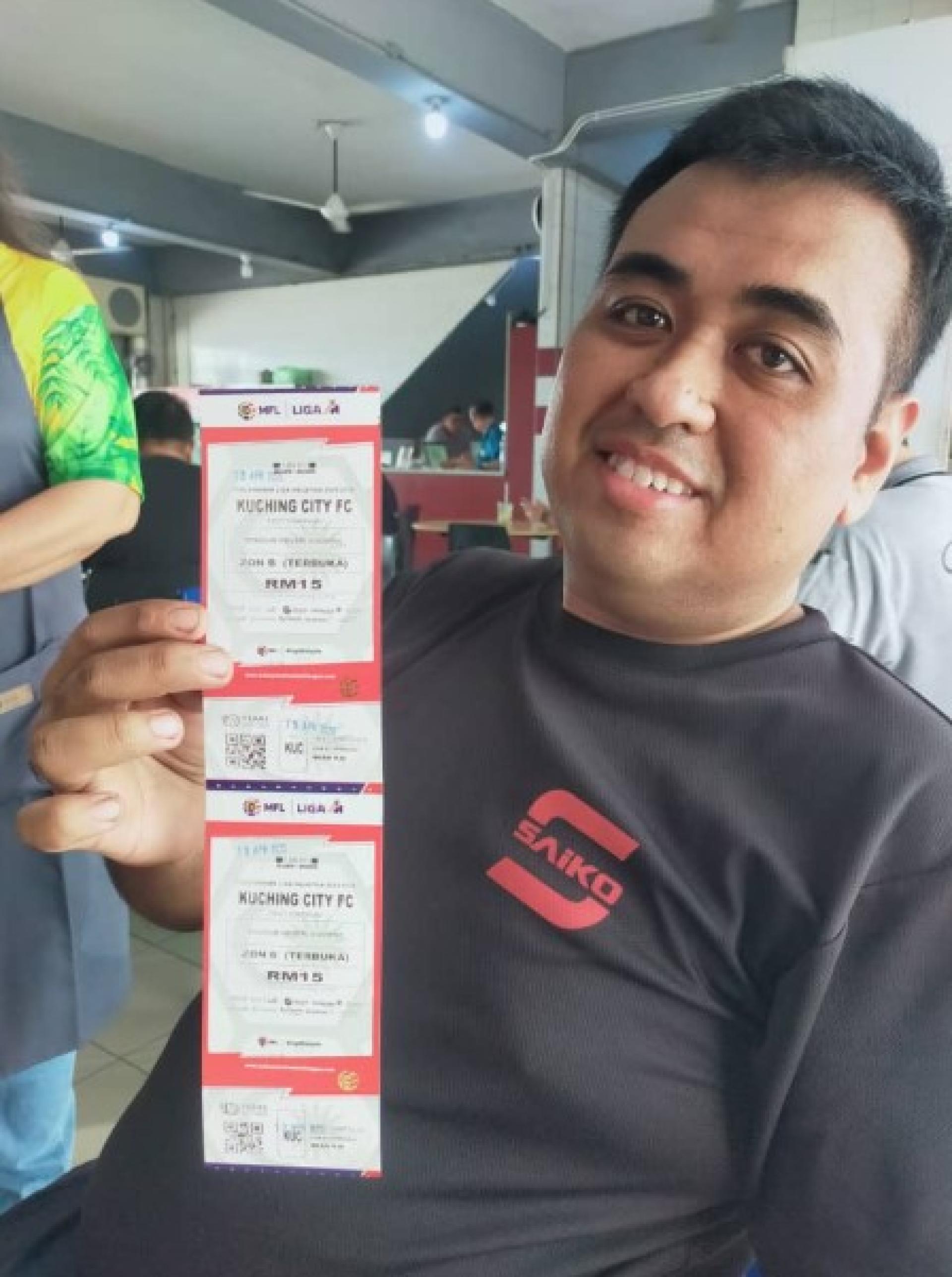 球迷沙哈依迪·布斯曼展示本周六比赛门票。