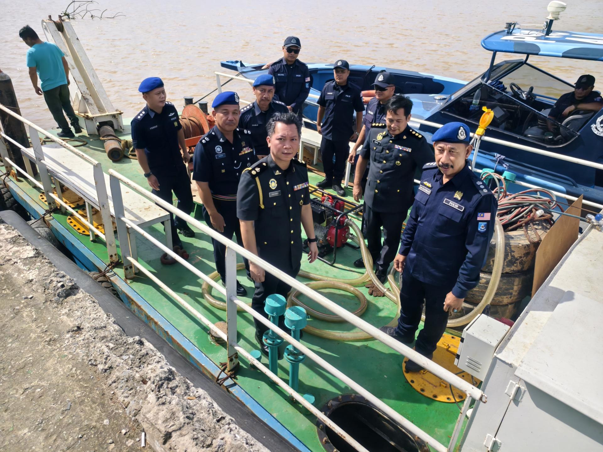 砂拉越第5区水警指挥官阿都拉曼助理总监（右）与执法人员在现场召开新闻发布会后登船检查合影。