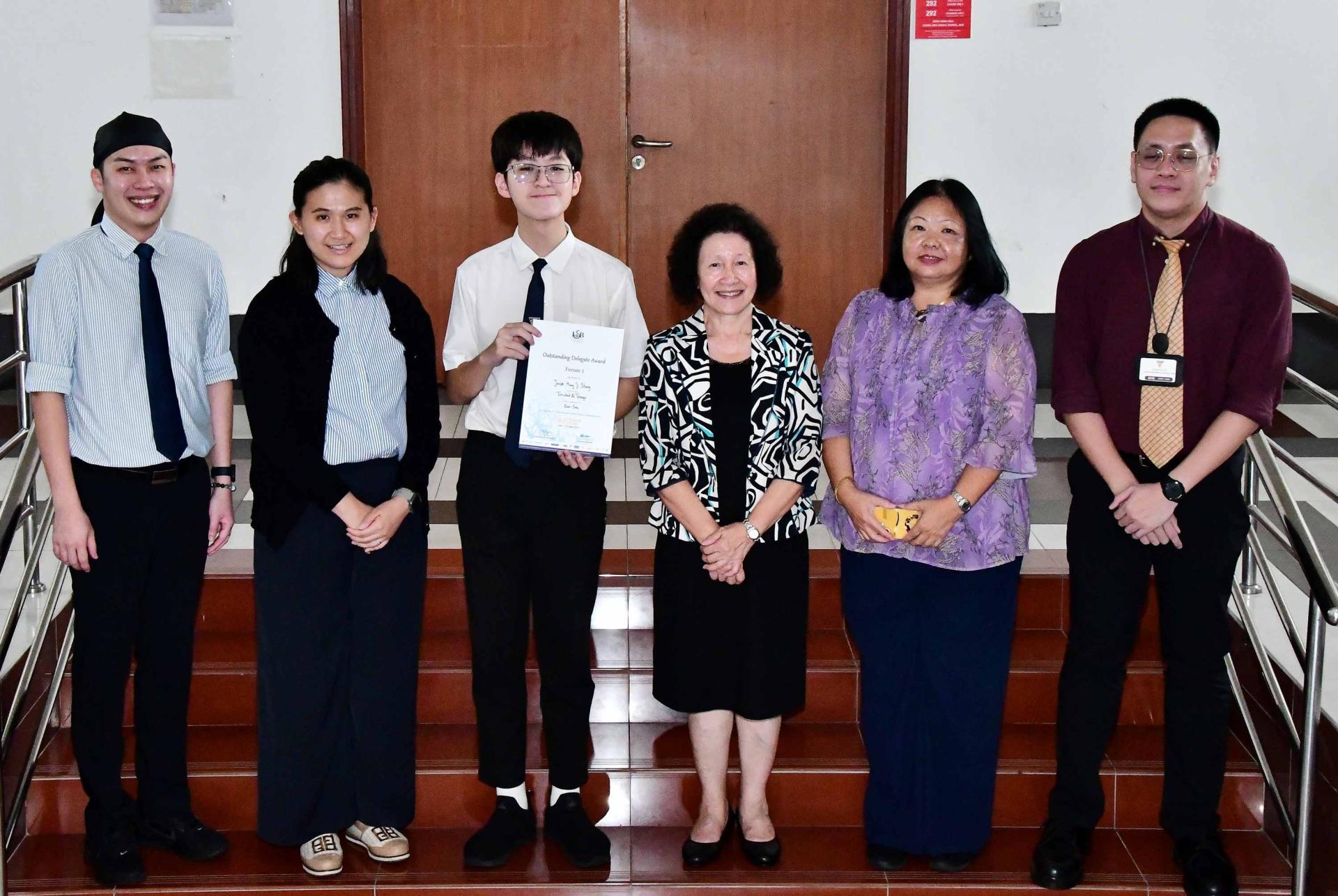 获奖的汶中生洪继升与许月兰校长（右3）、杜岫颖副校长（左2）、陈美典助理校长（右2）、英文部门主任鲍赈杰老师（左）及黎宽胜老师（右）合影。