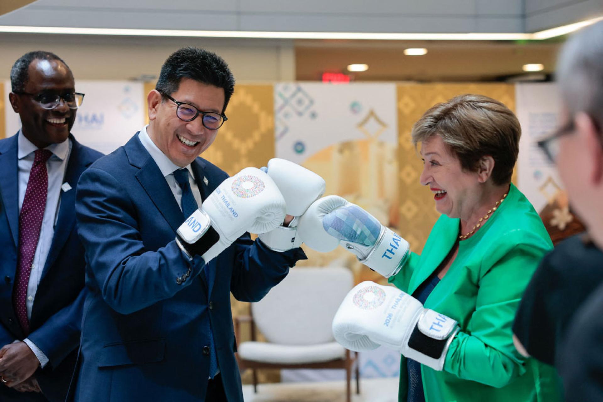 泰国财政部长（左）埃克尼提和国际货币基金组织总裁格奥尔基耶娃戴上手套比出打泰拳手势。