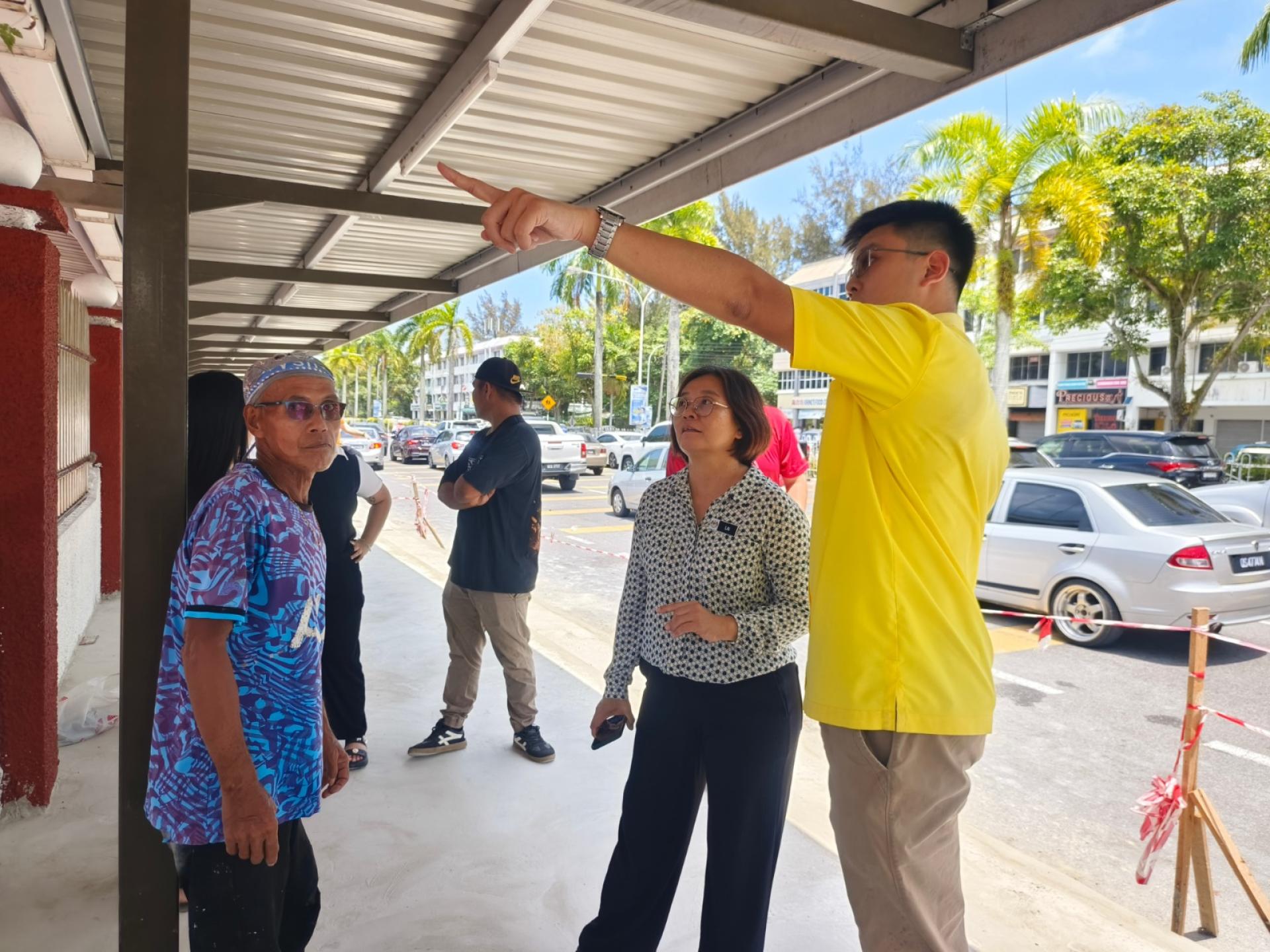 谢家洪（右）向美里中华中学校长赖佳玲（右2）讲解工程细节，包括增设座椅等设施。