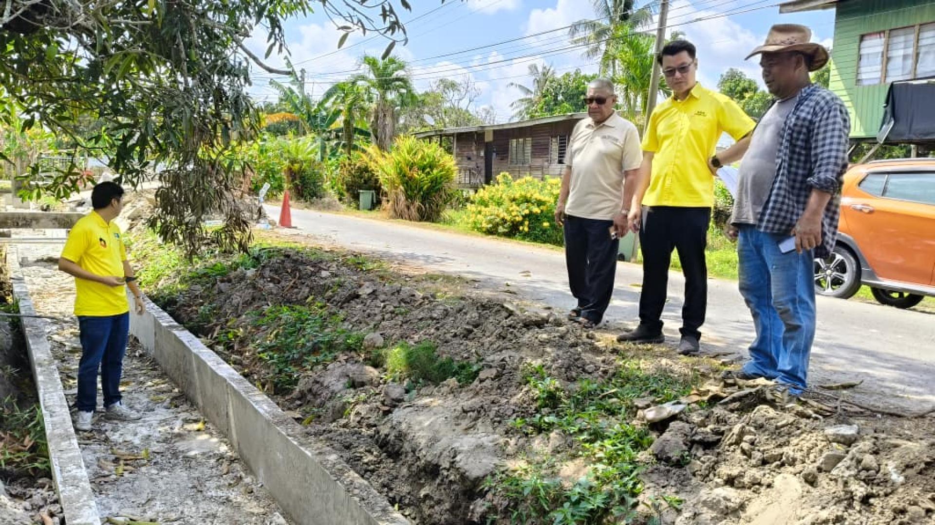 砂人联党卑尔骚支部青年团团长市议员刘奕杰（右２）巡视甘榜鲁哇2A路巷排水沟渠改善工程。