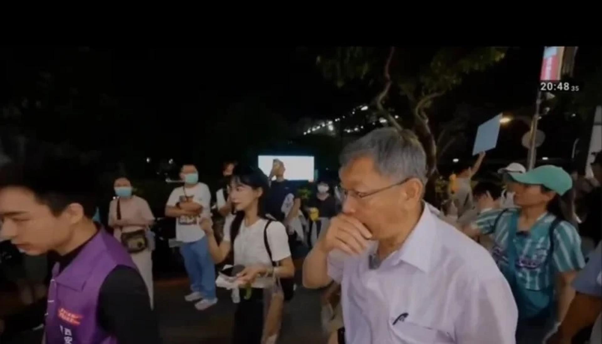 柯文哲手遮住鼻子，表情略有不适。
