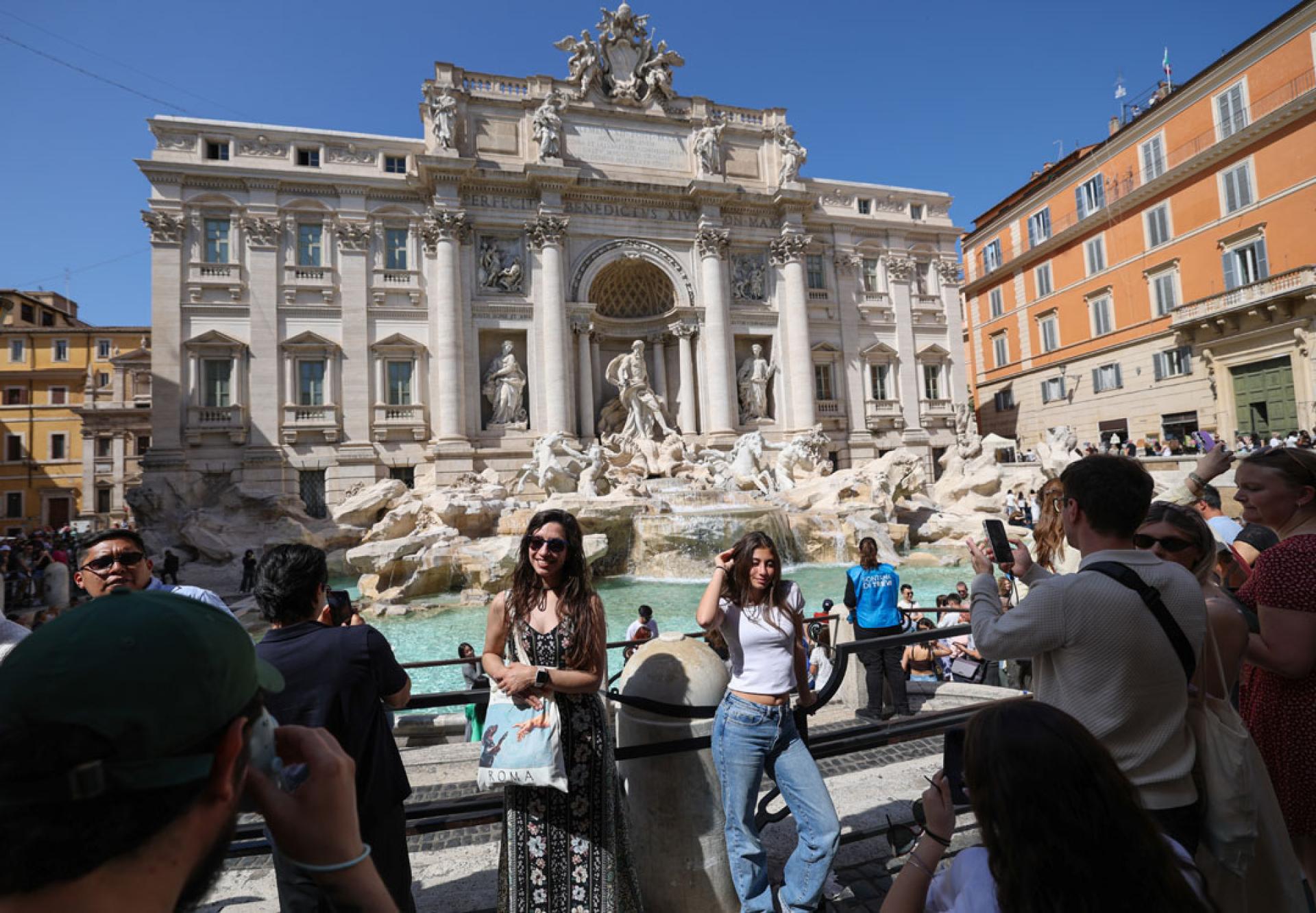 人们17日在意大利罗马的特莱维喷泉前拍照留念。（图：新华社）