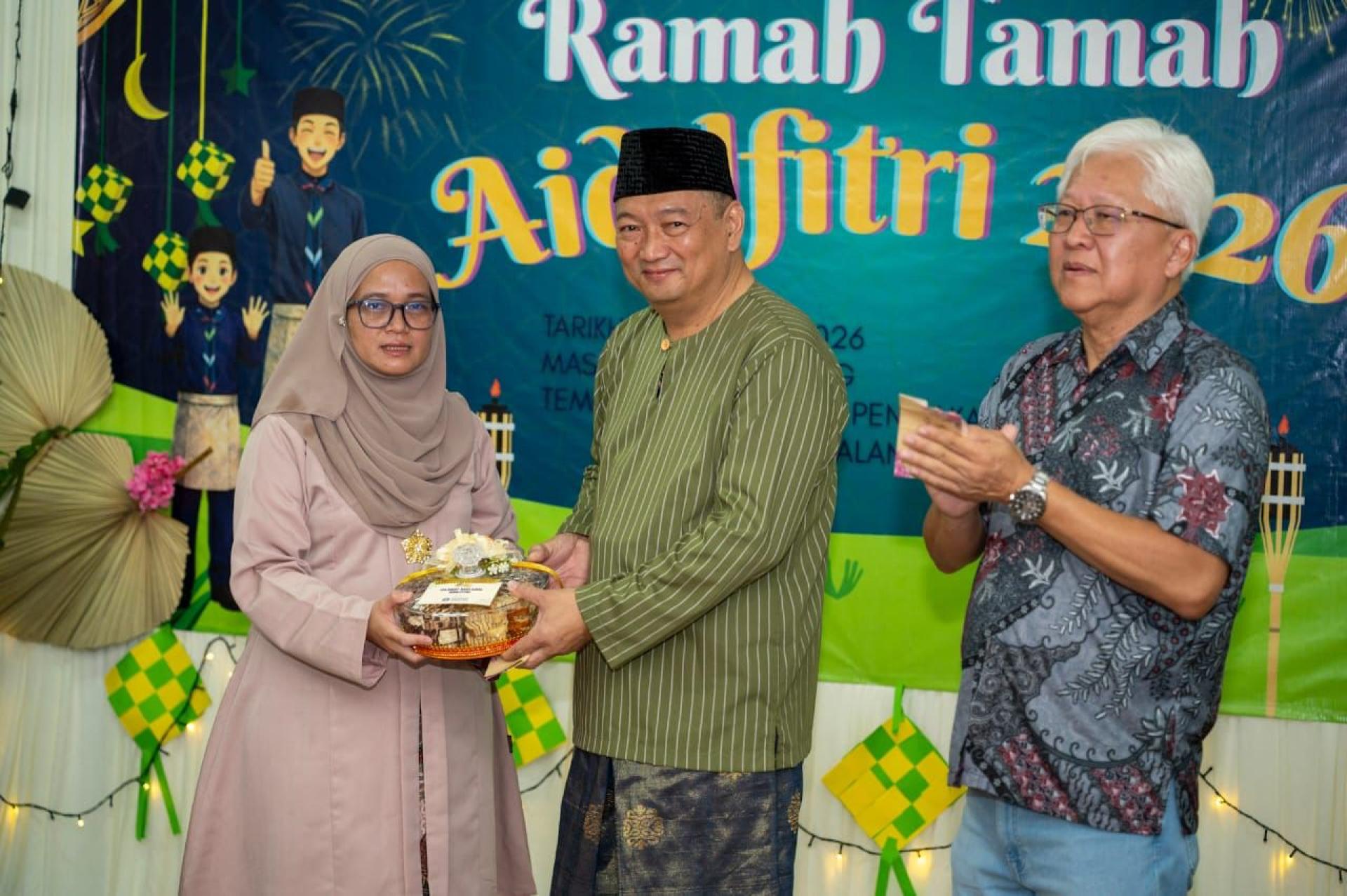 (左1) 达央苏海拉赠送开斋节蛋糕纪念品予砂拉越童军理事会副会⻓哈芝佐玛亚，砂拉越童军首席总监林文明陪同见证，场面温馨融洽。