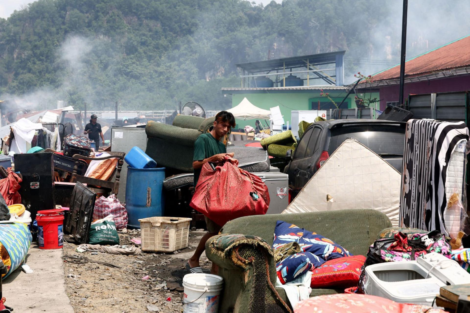 灾民将从大火中抢救出来的家具搬离现场。