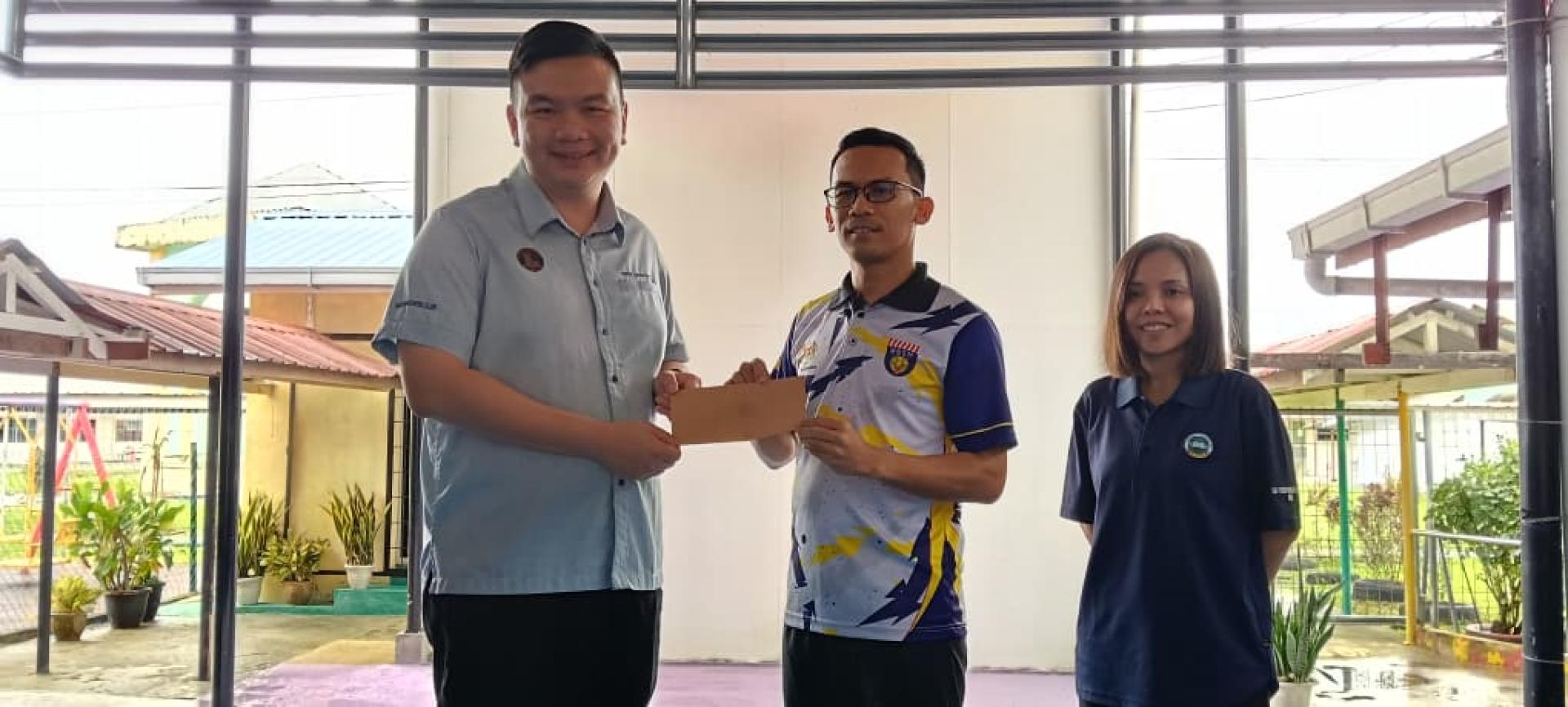 赵俊文（左）移交闭路电视安装拨款支票予特殊教育小学代表。