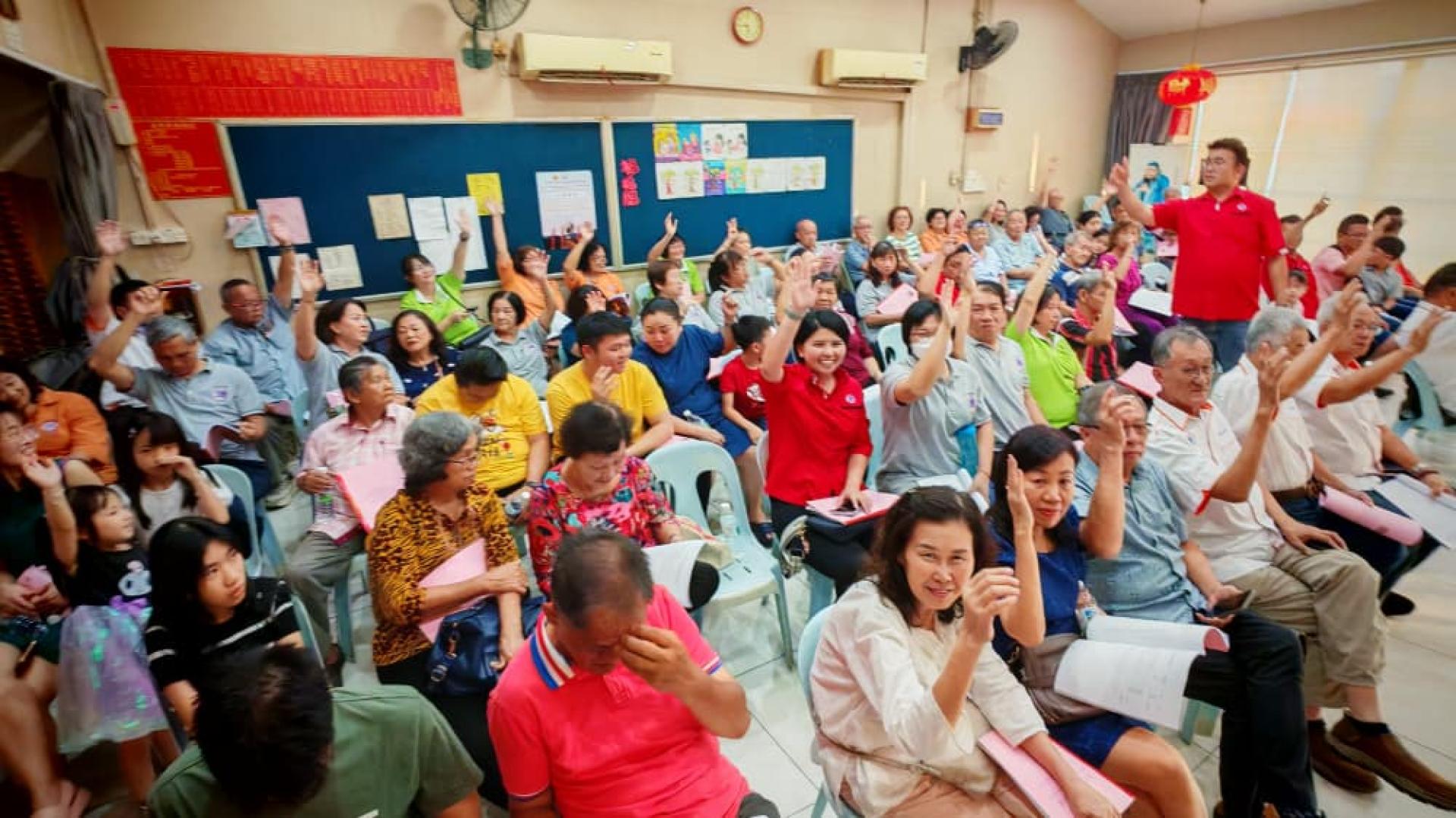 大会以举手方式进行表决。图为记录员点算举手同意人数。