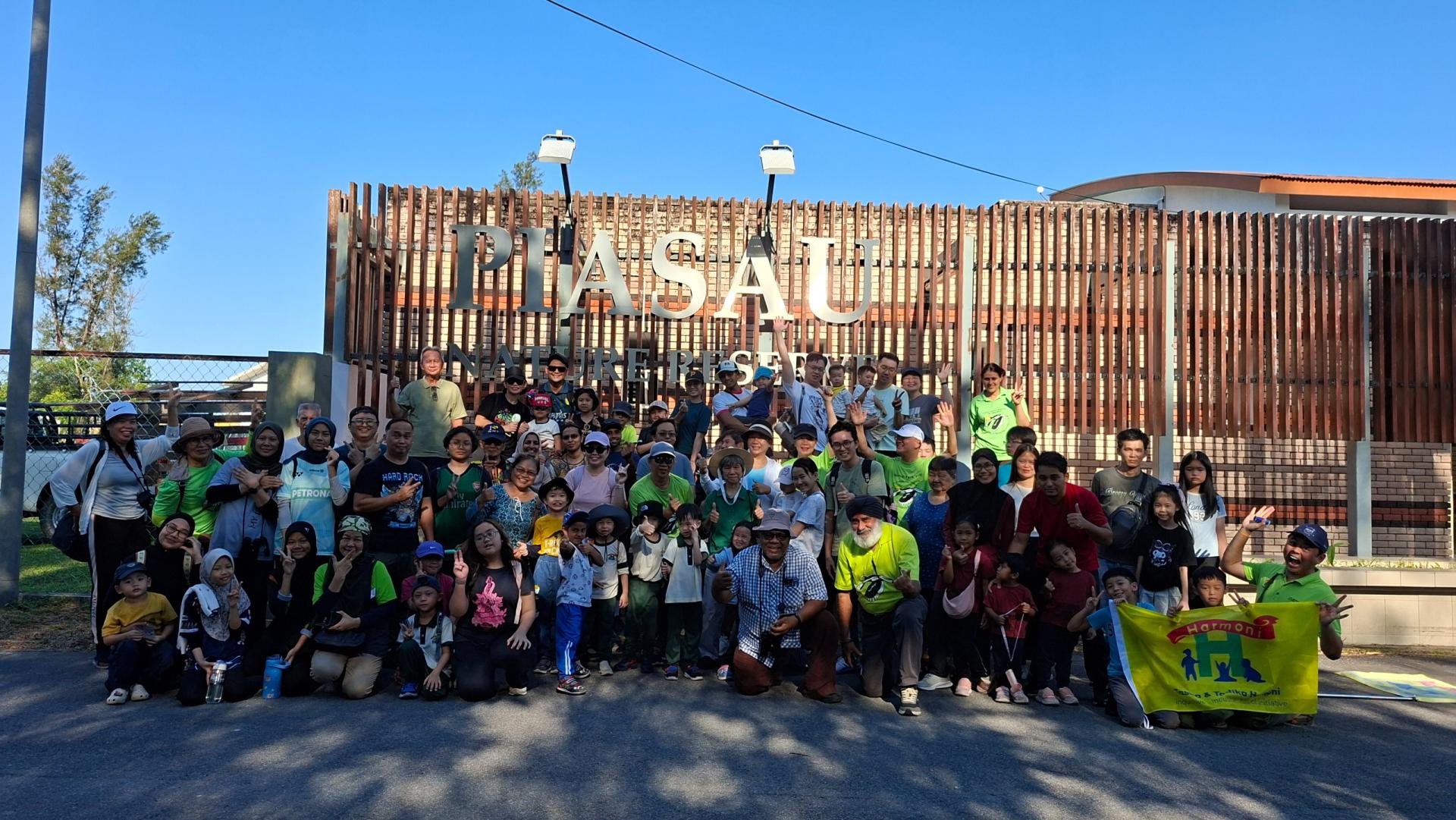 马来西亚自然协会美里分会主席慕沙慕斯巴（前排左）、卡兰比星（中）与林保新校长（右）及参与者在卑尔骚自然保护区解说中心入口处集合。