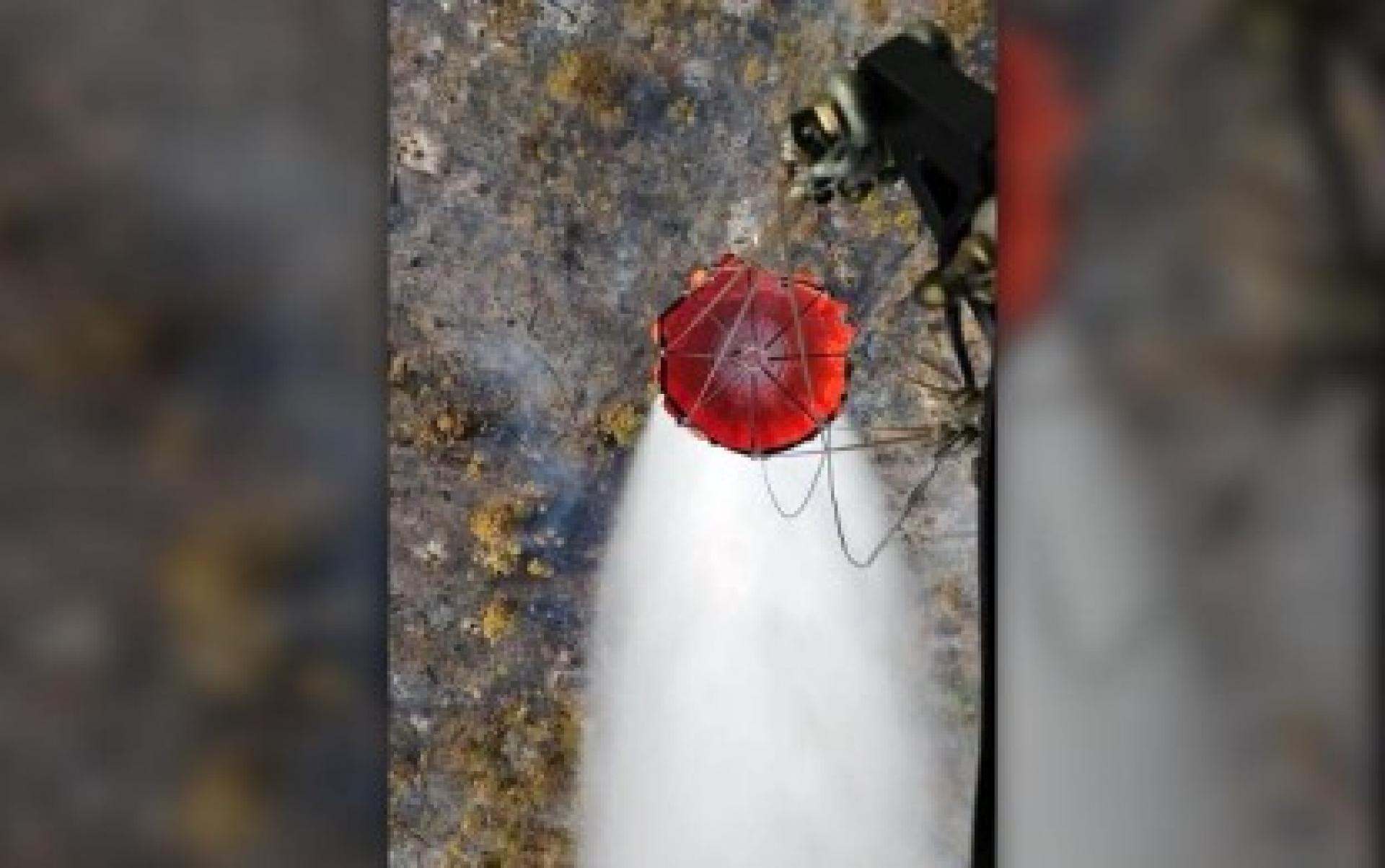 菲律宾空军一架S-70i黑鹰直升机周日携带吊桶，对东萨马省吉万市奥莫农岛上爆发的森林大火展开空中灭火行动。