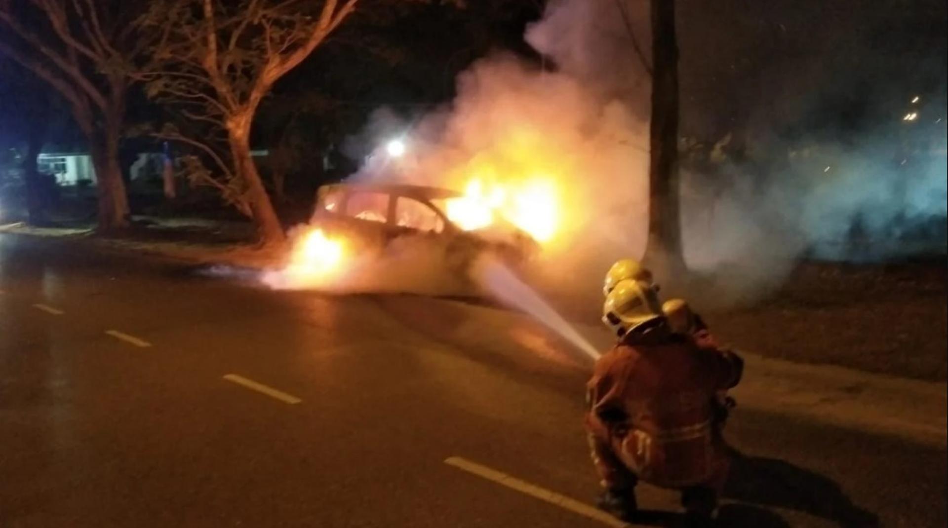 消防员在深夜车辆火灾现场进行灭火工作。