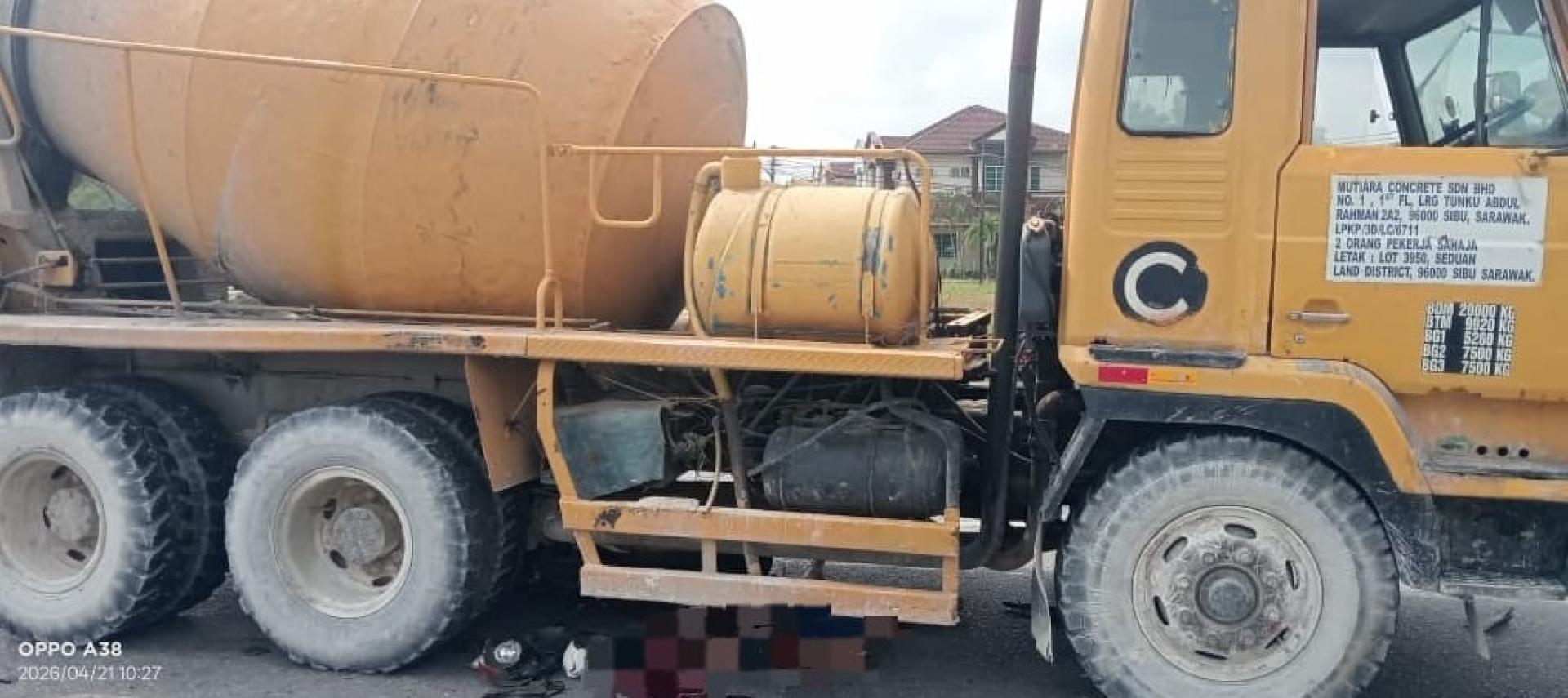 现场照片显示，死者遗体被夹在水泥罗里车底。