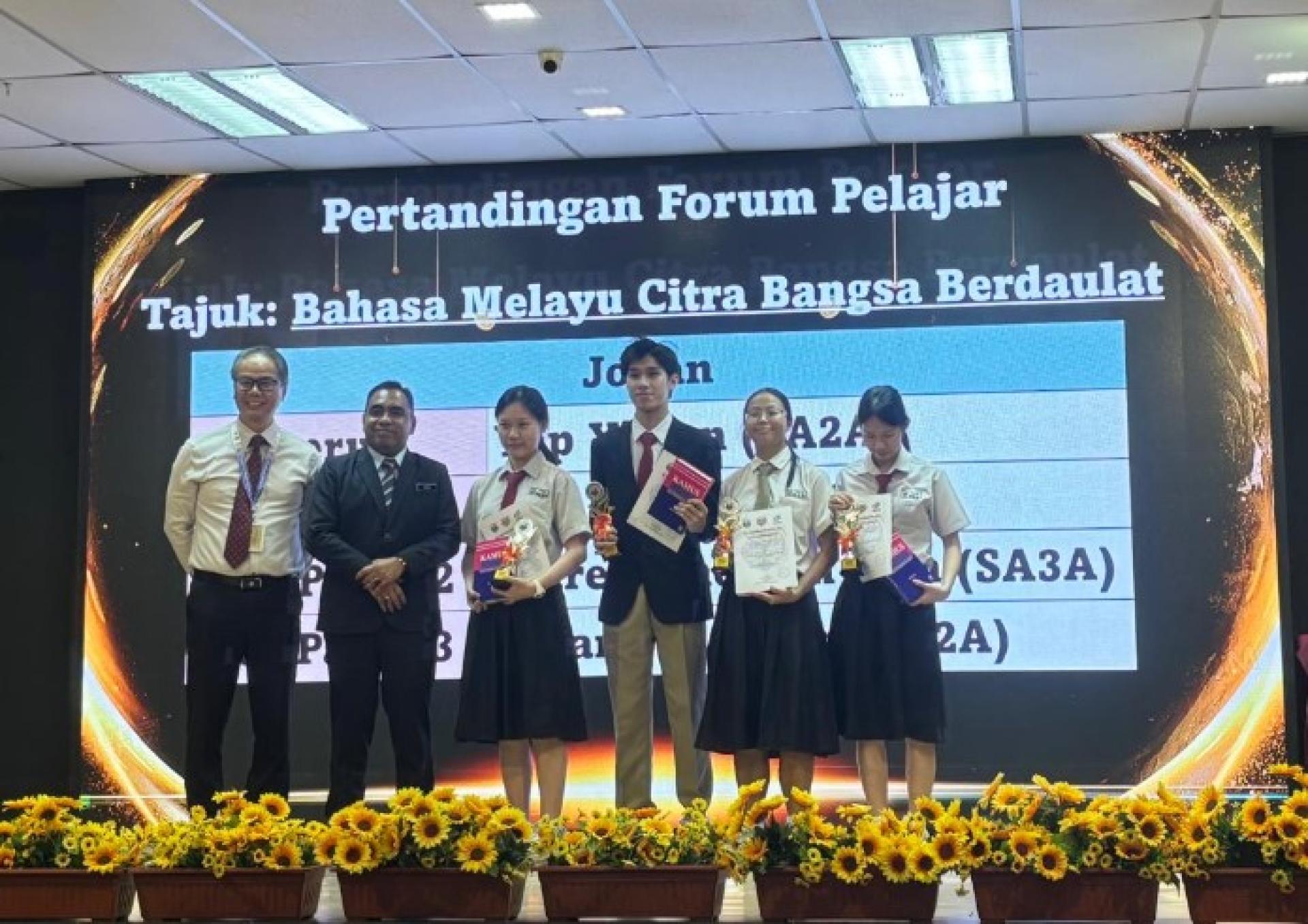 拿督阿兹祖（左2）在古晋中华中学第一校2026年国语月活动颁奖礼上颁奖予得奖者。