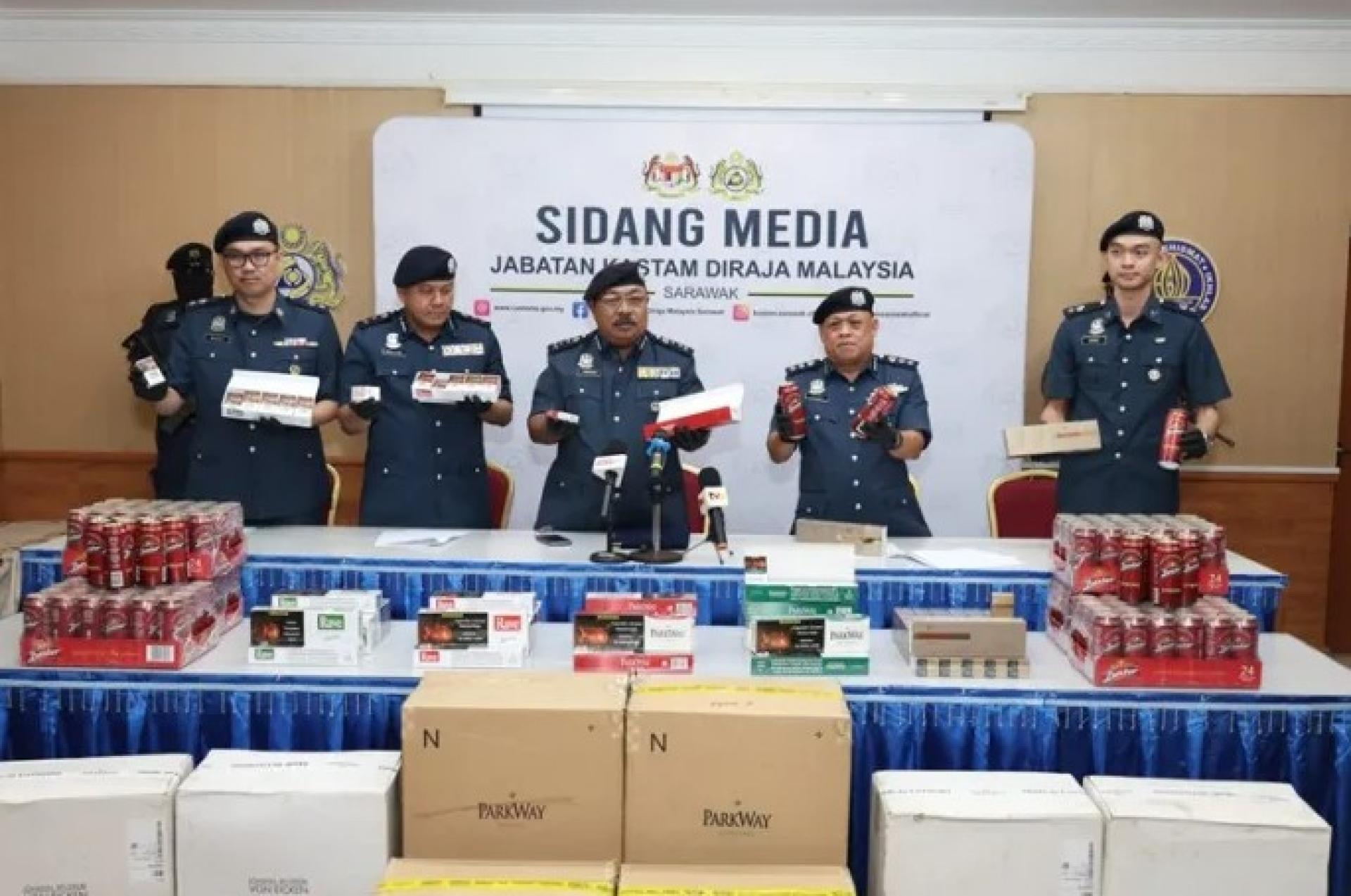 Norizan（中）与关税局官员展示起获的私烟及酒类。