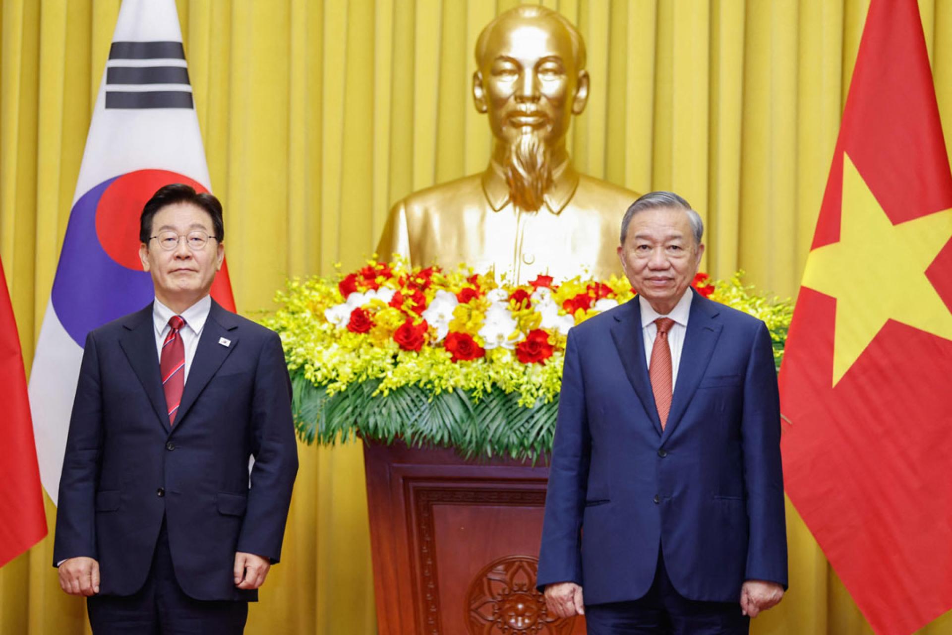 越南国家主席苏林（右）和韩国总统李在明（左）22日在河内总统府出席协议交换仪式。