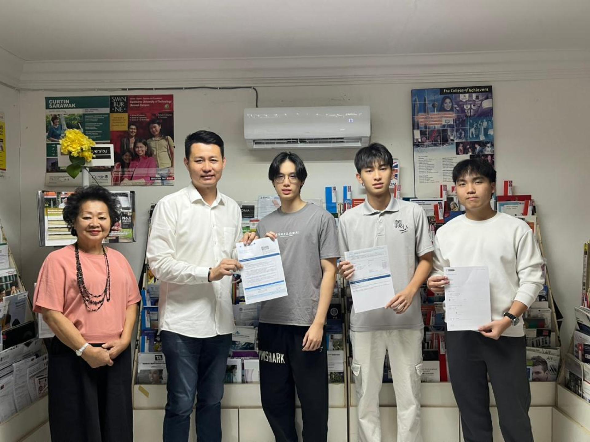 赞助人林思健（左2）在合作单位负责人林芳仙（左1）的陪同下移交飞机票给其中三位成功在升学展获得录取的大专生时摄。