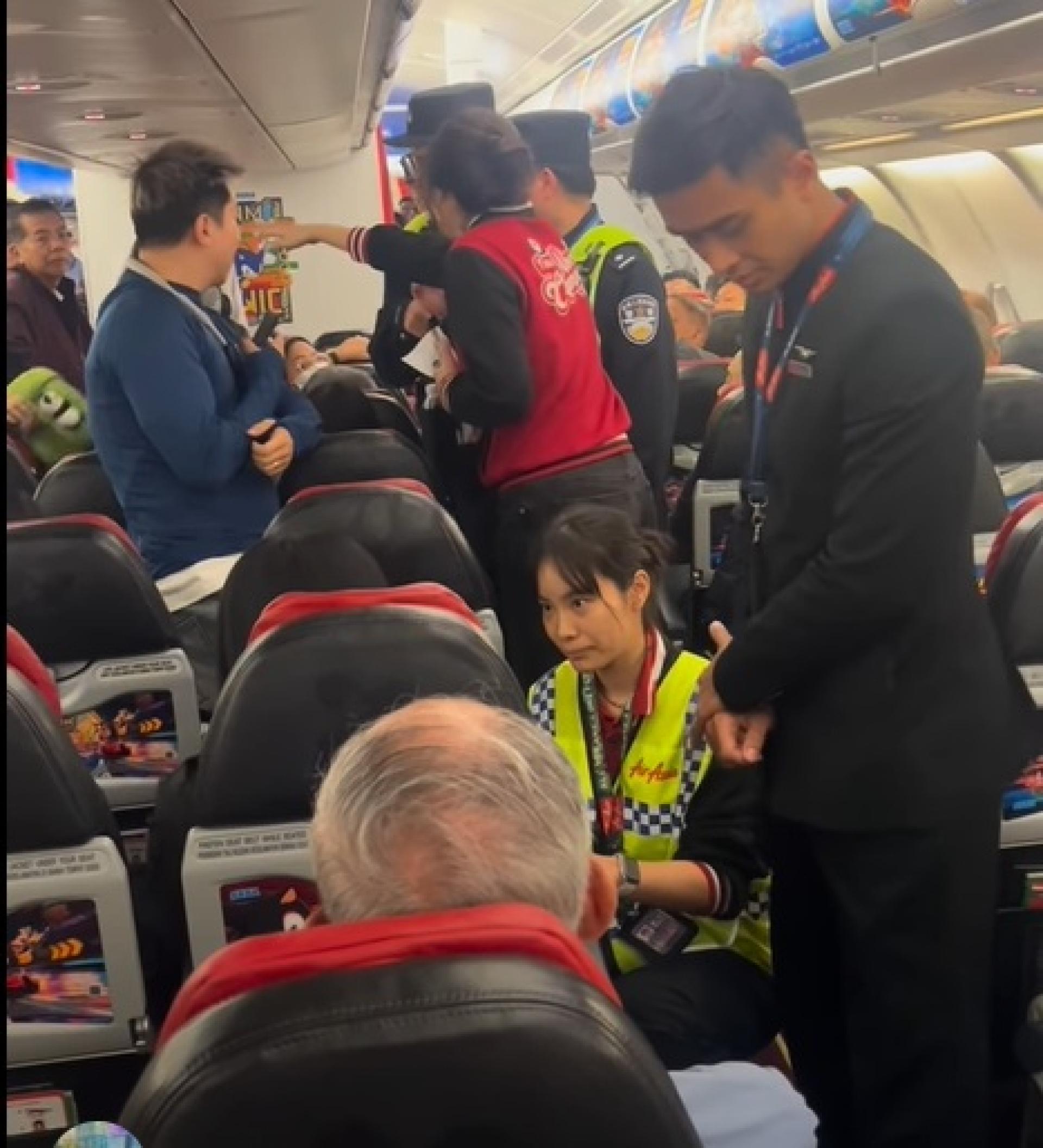 女地勤人员蹲着，以专业聆听女子不满诉求，获网民赞扬。