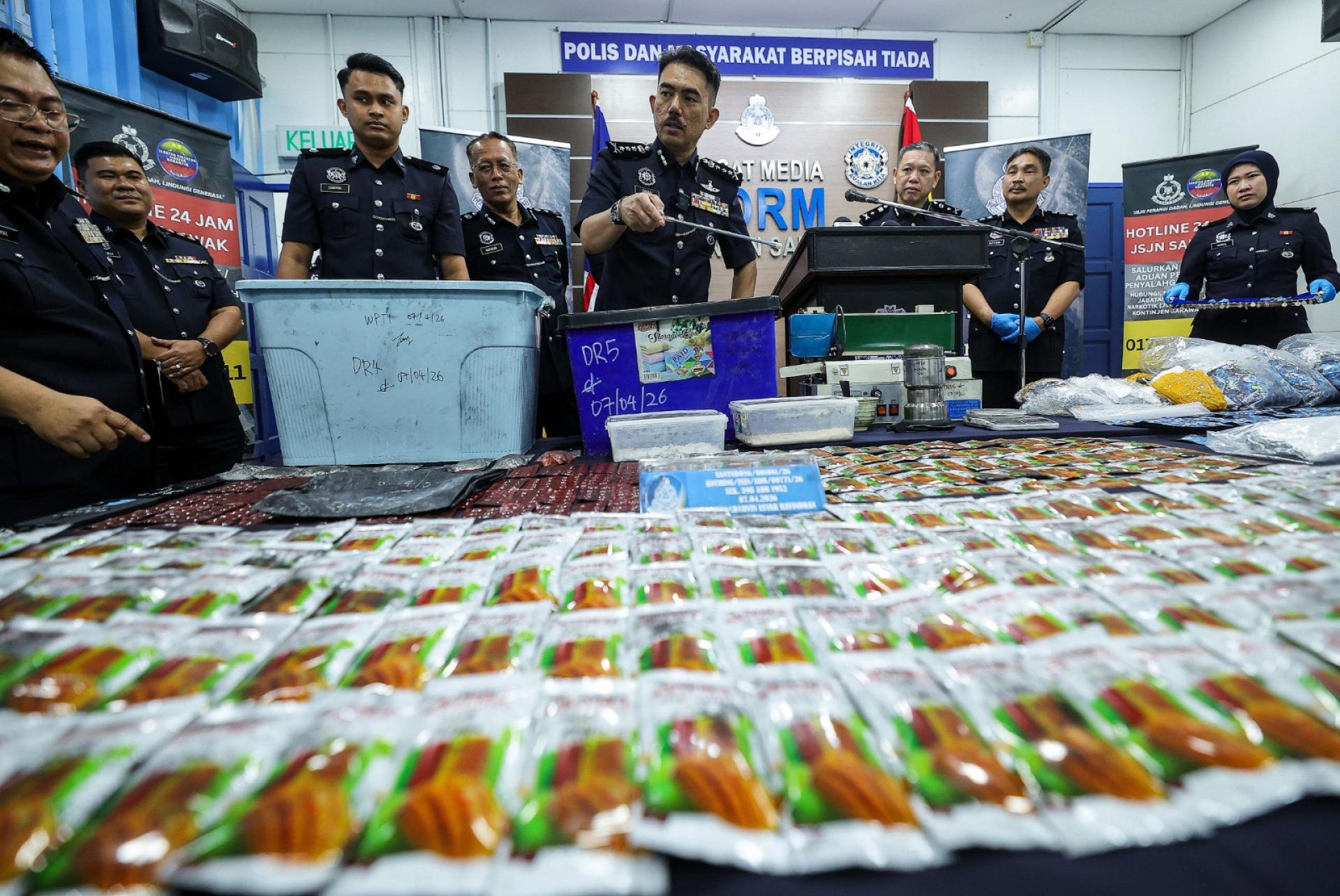 莫哈末再纳（右4）展示警方起获的大批毒品。