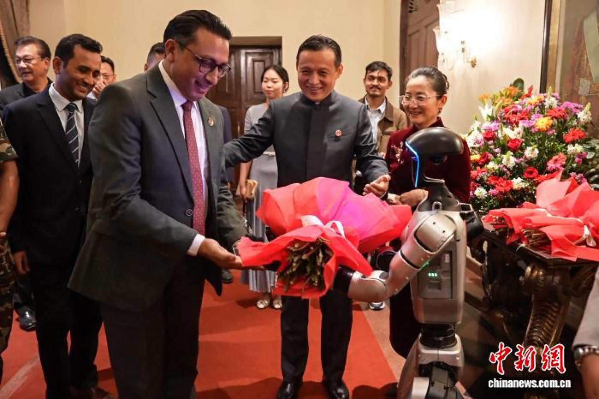 尼泊尔财政部长瓦格勒从宇树机器人手中接过欢迎花束。