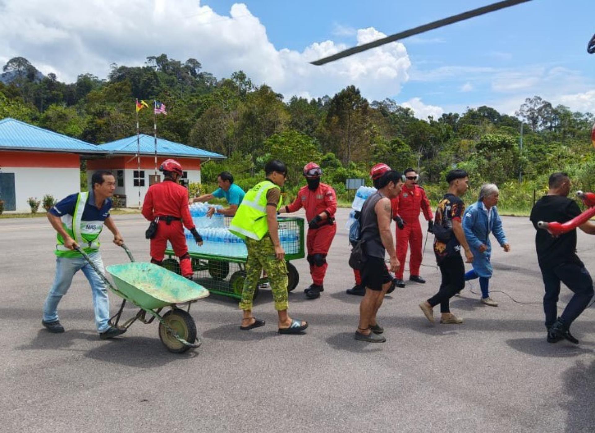 志愿者与地方当局正在卸载运往弄勒浪受灾家庭的救援物资。（图片：UKAS）