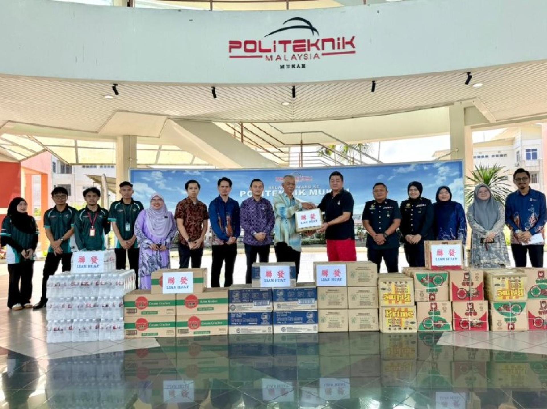 Suhaili（左9）在活动中从Kelvin（右6）手中接过食物银行捐赠物资。