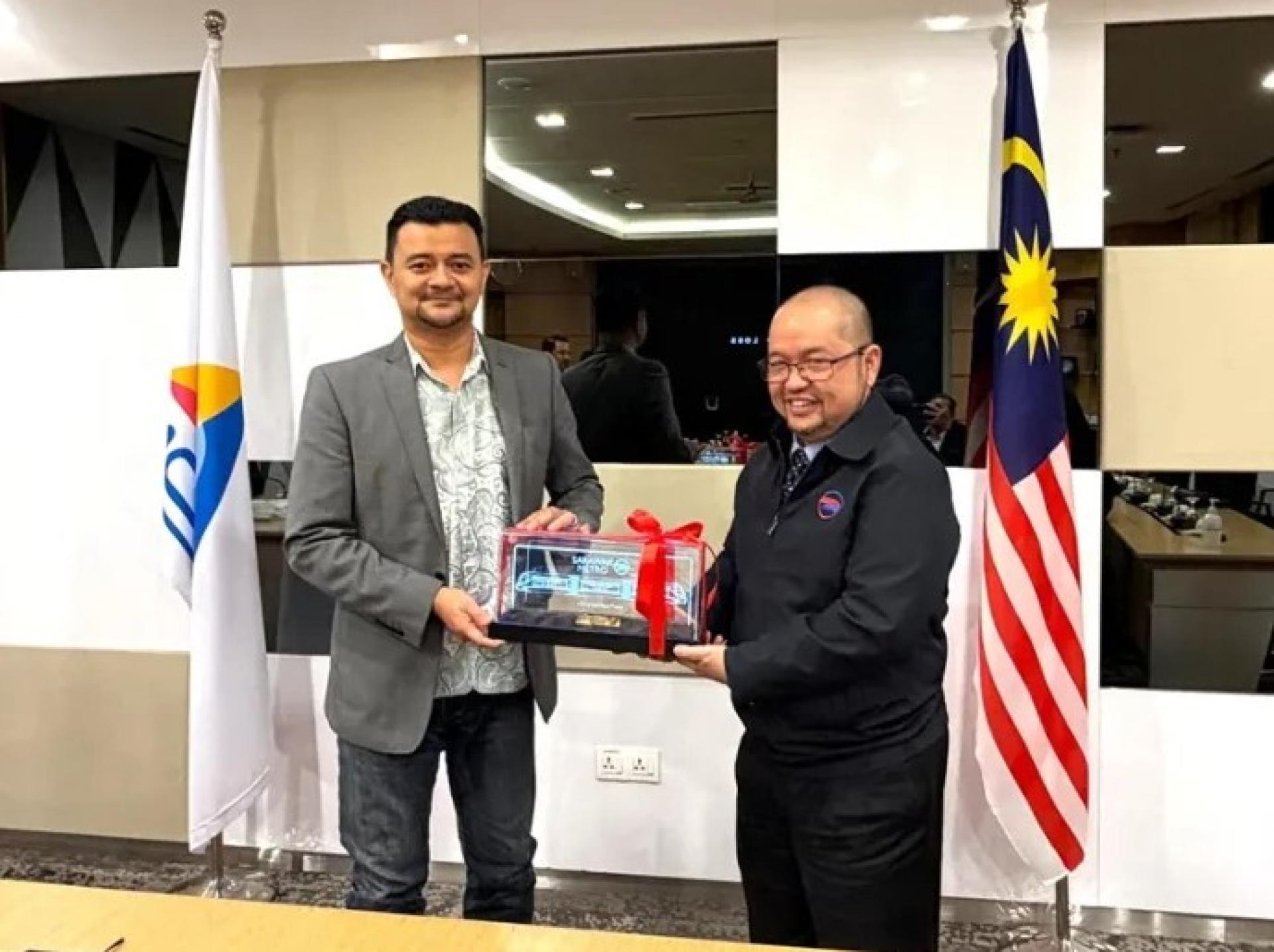 Mazli（右）在近期访问赛城MCMC总部时向Ahmad Nasruddin致赠纪念品。