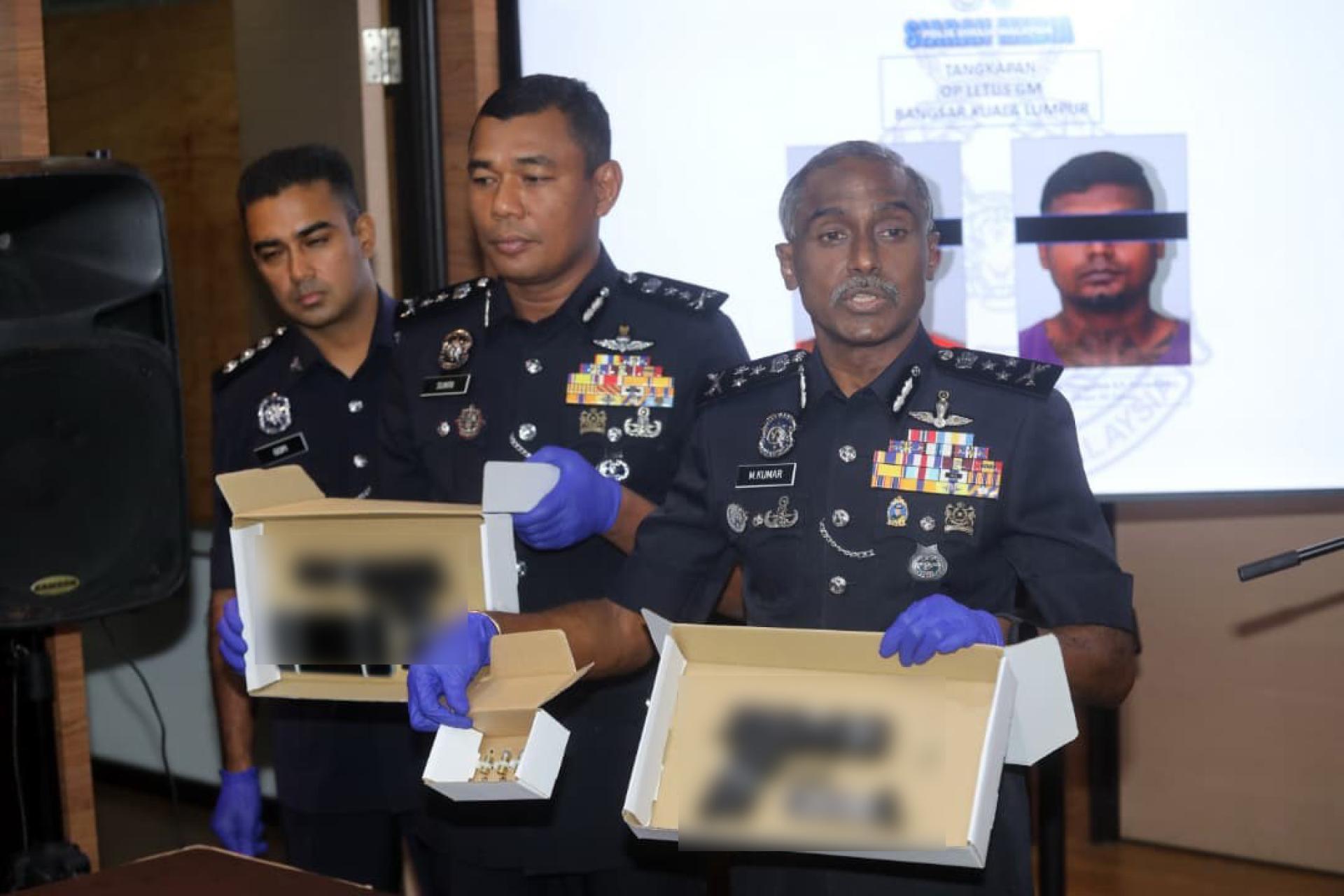 古马（右）在记者会上出示警方搜到的CZ实枪、子弹及一把疑似仿真枪仿等证物。