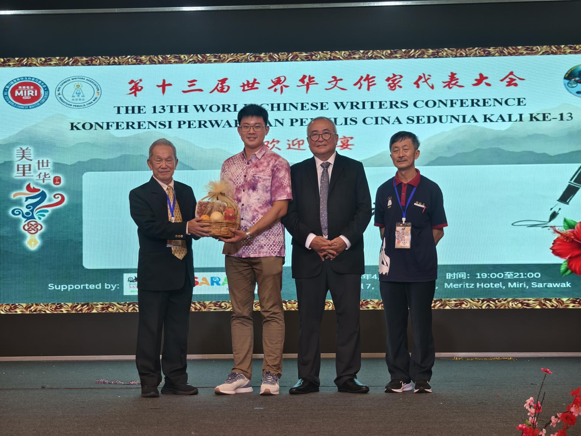 世界华文作家协会总会长兼大会主席孙德安赠送纪念品予主宾砂拉越旅游副部长拿督陈超耀律师，由代表谢家洪代为接领。右起为美里笔会主席许敬平及特别嘉宾美里市市长俞小珊。