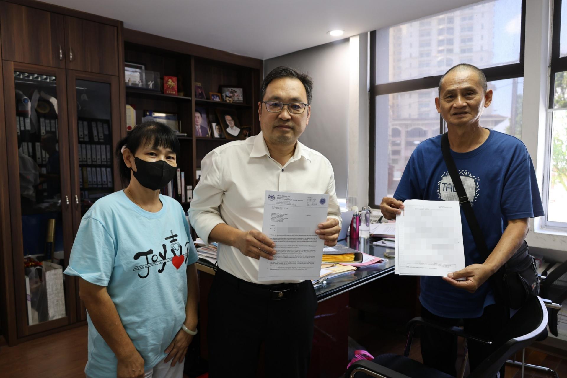 砂行动党主席兼国州议员张健仁（中） 与长者王先生夫妇分别展示致给BSN银行砂拉越的局长的函件和相关申诉文件。