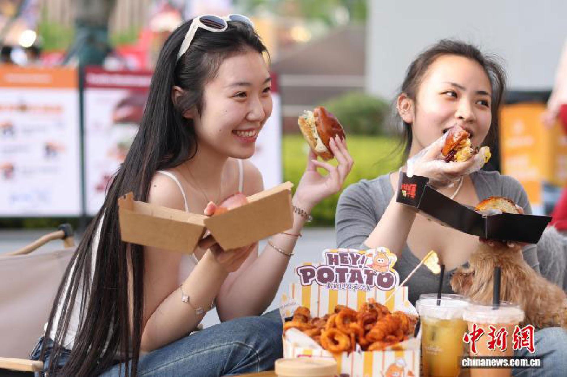 4月24日，江苏南京，年轻人在汉堡节上品味汉堡。